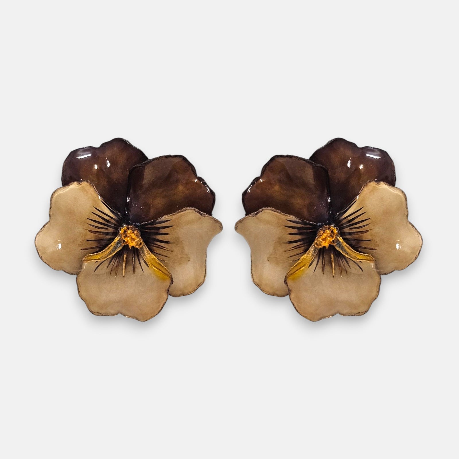 pareja de pendientes con forma de flor de pensamiento de Ciléa Paris, destacando sus pétalos superiores marrón caramelo y sus pétalos inferiores rosa claro.