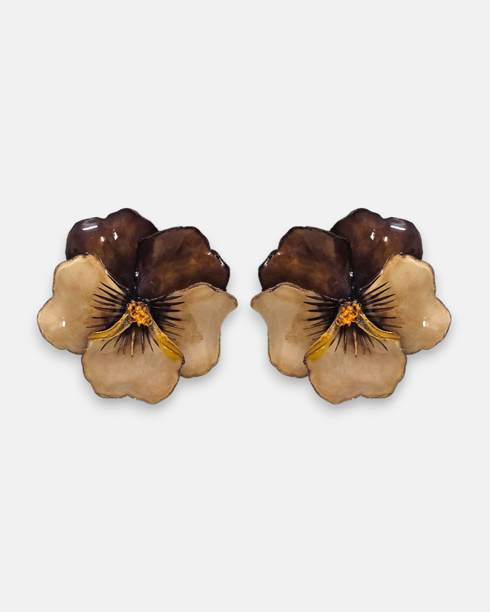 pareja de pendientes con forma de flor de pensamiento de Ciléa Paris, destacando sus pétalos superiores marrón caramelo y sus pétalos inferiores rosa claro.
