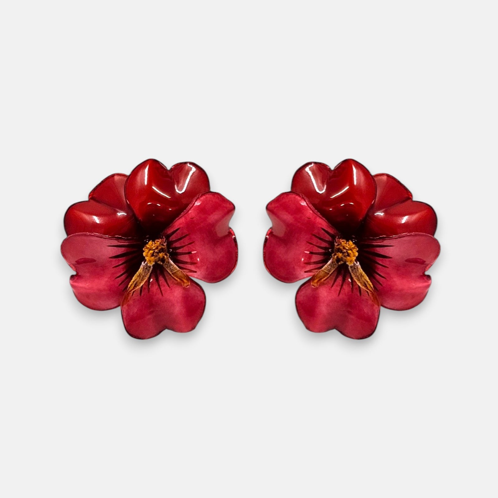 pareja de pendientes con forma de flor de pensamiento de Ciléa Paris, destacando sus pétalos superiores rojo oscuro y sus pétalos inferiores en color fucsia o rosa intenso brillante.