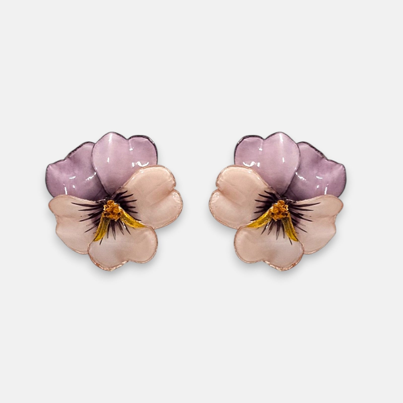 pareja de pendientes con forma de flor de pensamiento de Ciléa Paris, destacando sus pétalos superiores de color malva claro y sus pétalos inferiores en tono crema brillante.