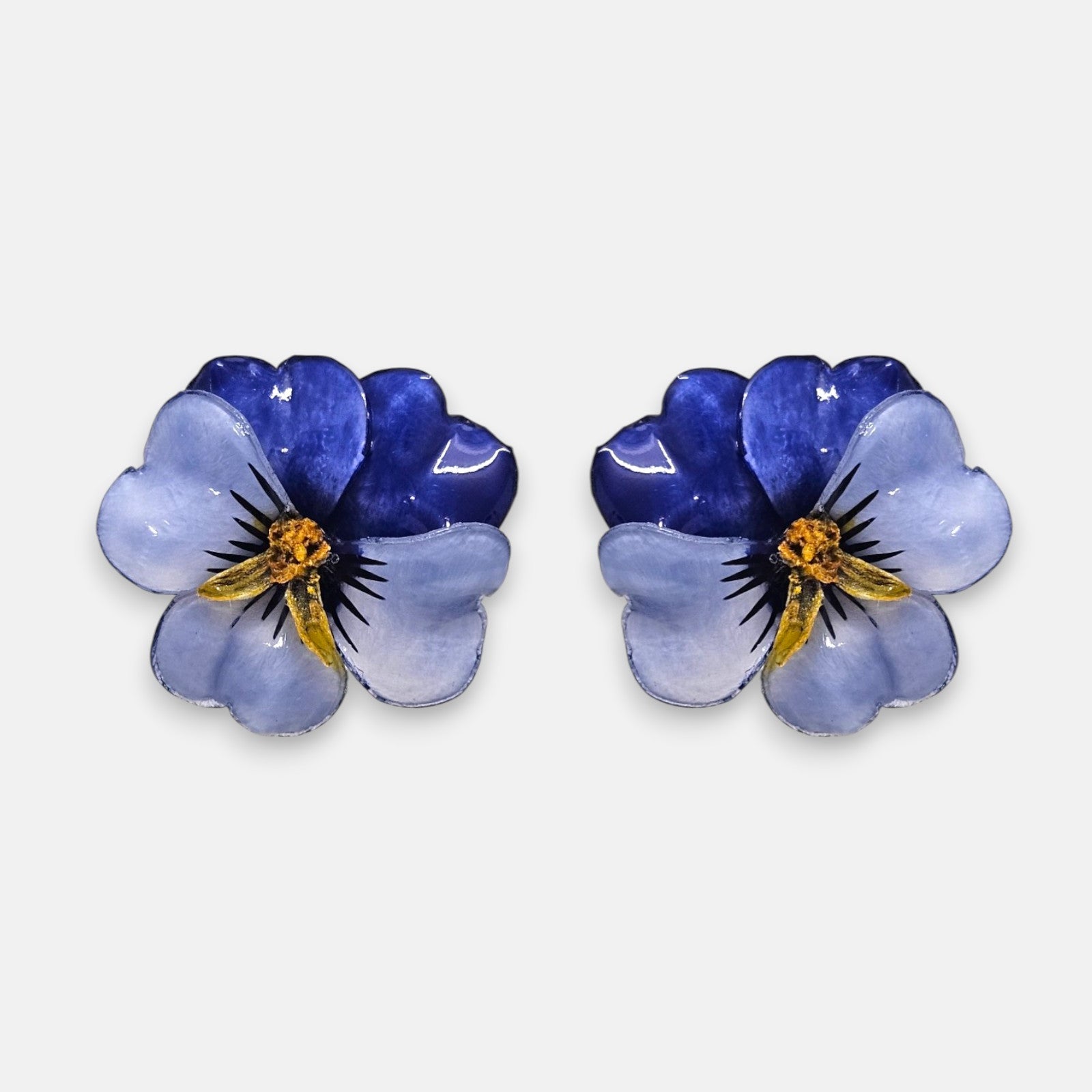 pareja de pendientes con forma de flor de pensamiento de Ciléa Paris, destacando sus pétalos superiores azul índigo oscuro y sus pétalos inferiores en color azul lavanda claro brillante.