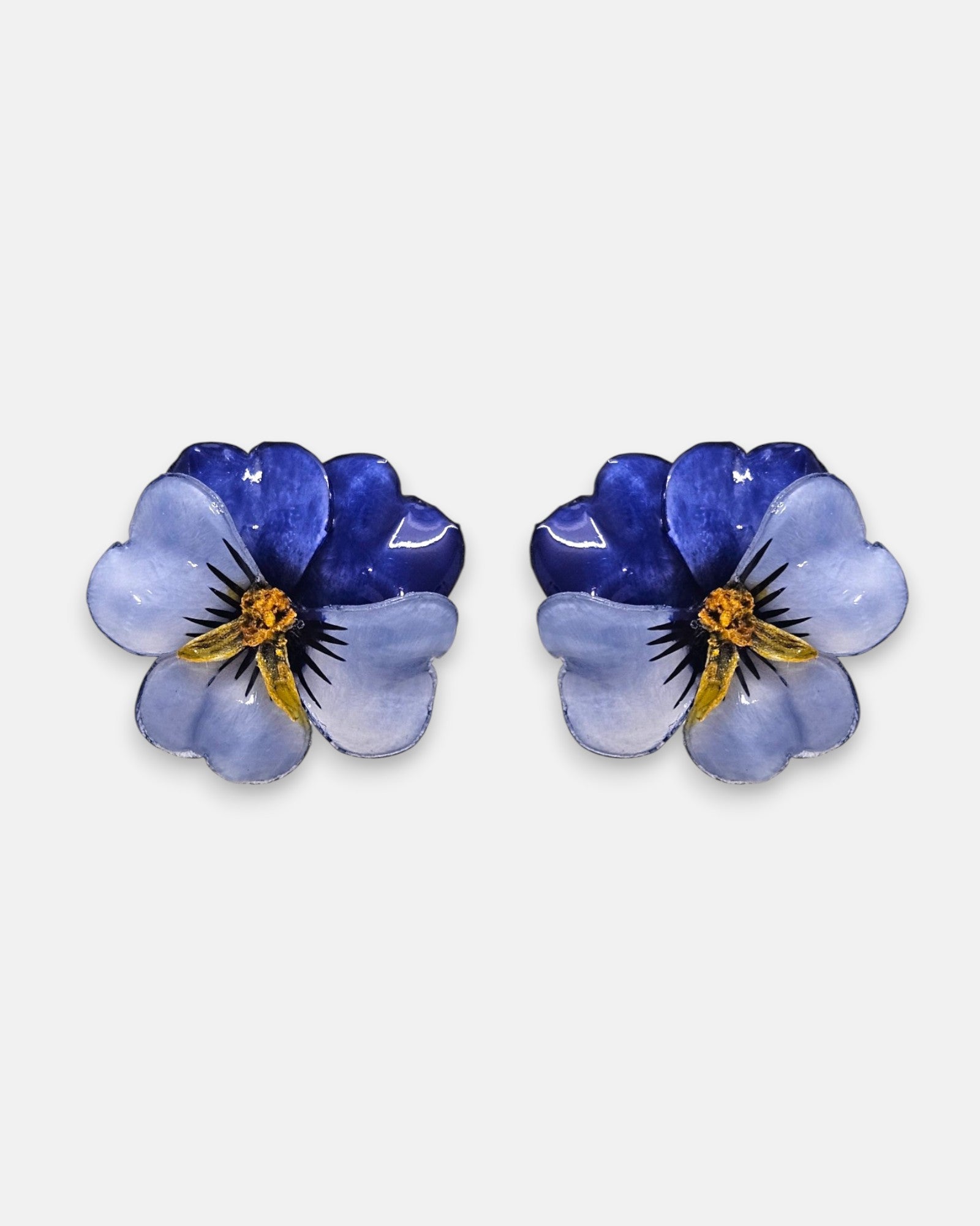 pareja de pendientes con forma de flor de pensamiento de Ciléa Paris, destacando sus pétalos superiores azul índigo oscuro y sus pétalos inferiores en color azul lavanda claro brillante.