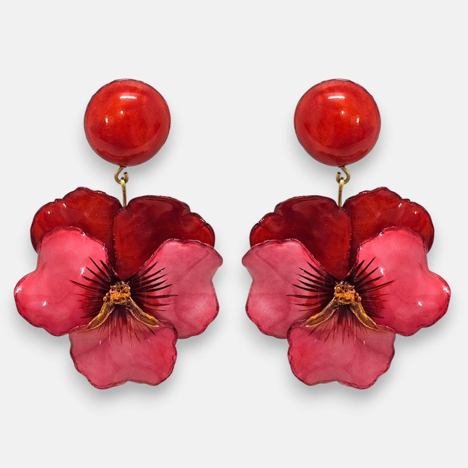 pareja de pendientes colgantes maxi con forma de flor de pensamiento de Ciléa Paris, destacando sus pétalos superiores en color rojo carmín profundo, pétalos inferiores fucsia brillante y un gran botón superior esférico a juego.