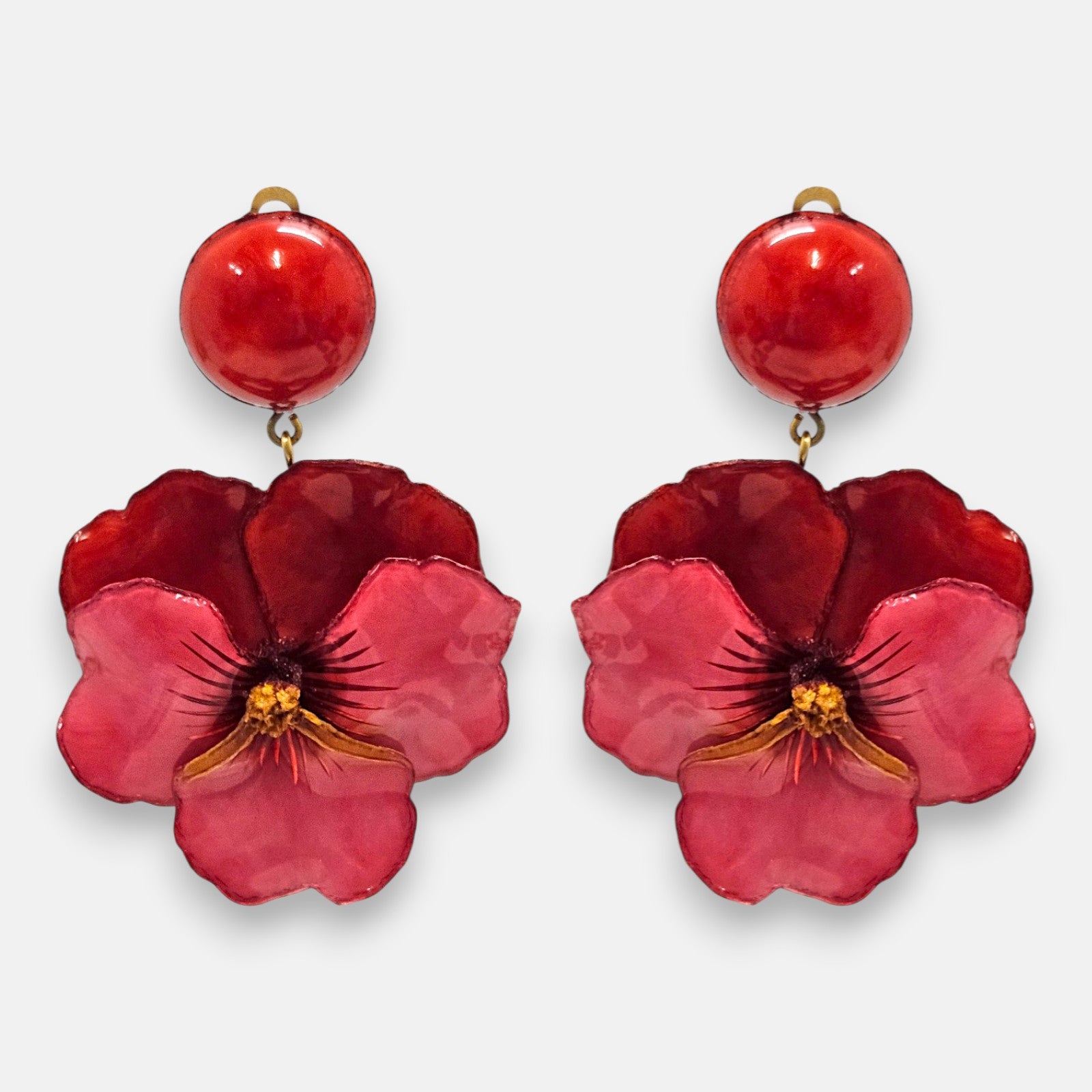 pareja de pendientes colgantes maxi con forma de flor de pensamiento de Ciléa Paris, destacando sus pétalos superiores en color rojo carmín profundo, pétalos inferiores fucsia brillante y un gran botón superior esférico a juego.