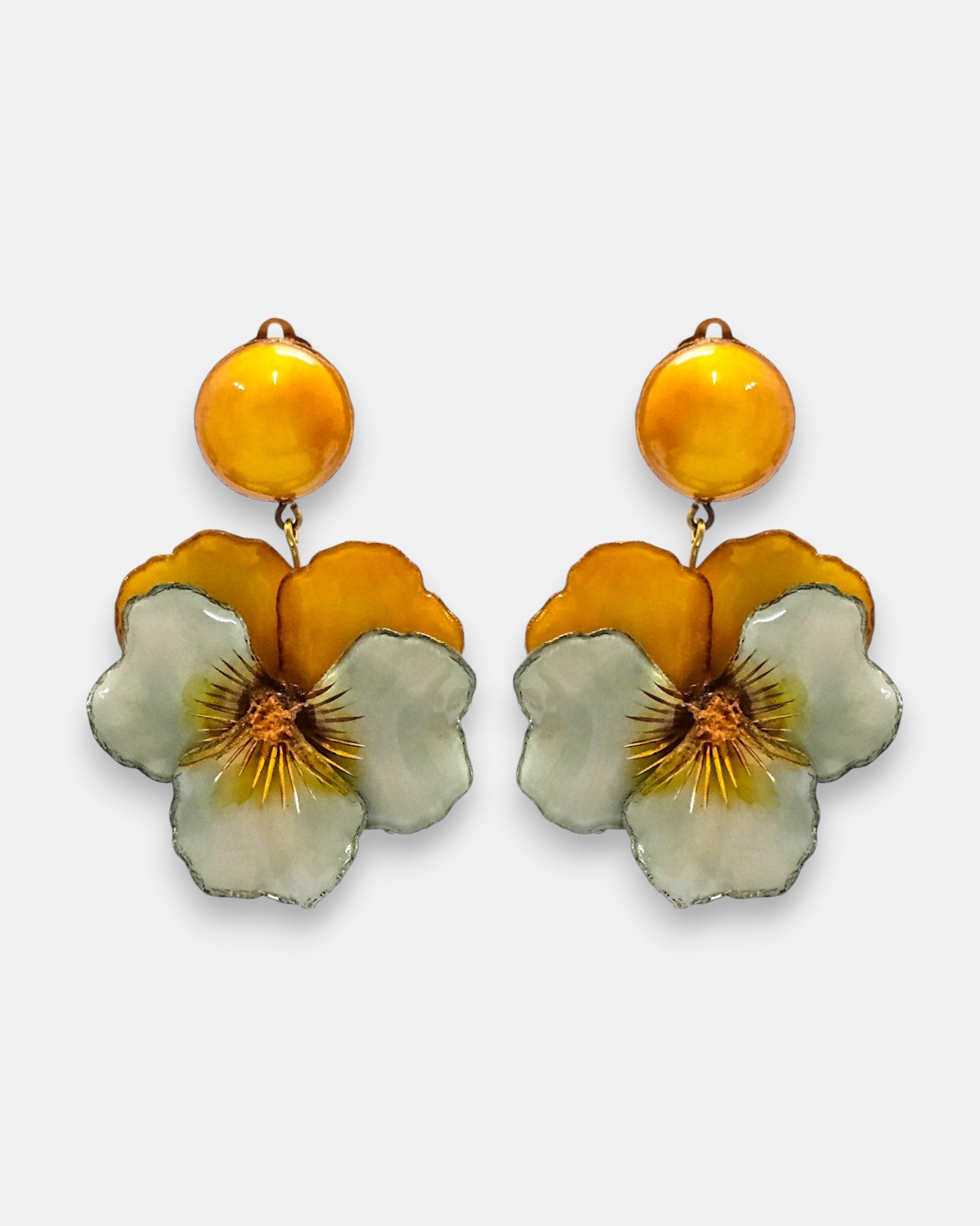 pareja de pendientes colgantes maxi con forma de flor de pensamiento de Ciléa Paris, destacando sus pétalos superiores en color ocre ámbar, pétalos inferiores verde menta suave y un gran botón superior esférico amarillo a juego.