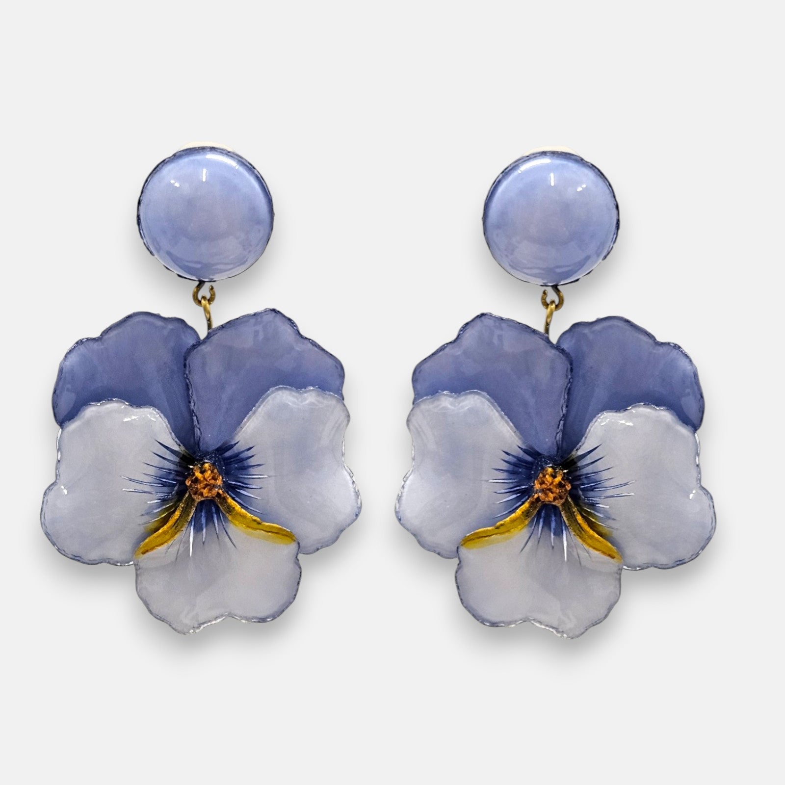 pareja de pendientes colgantes maxi con forma de flor de pensamiento de Ciléa Paris, destacando sus pétalos superiores en color violeta translúcido, pétalos inferiores en azul lavanda claro y un gran botón superior esférico a juego.