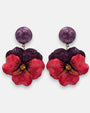 pareja de pendientes colgantes maxi con forma de flor de pensamiento de Ciléa Paris, destacando sus pétalos superiores en color violeta oscuro, pétalos inferiores en rojo rubí brillante y un gran botón superior esférico a juego.