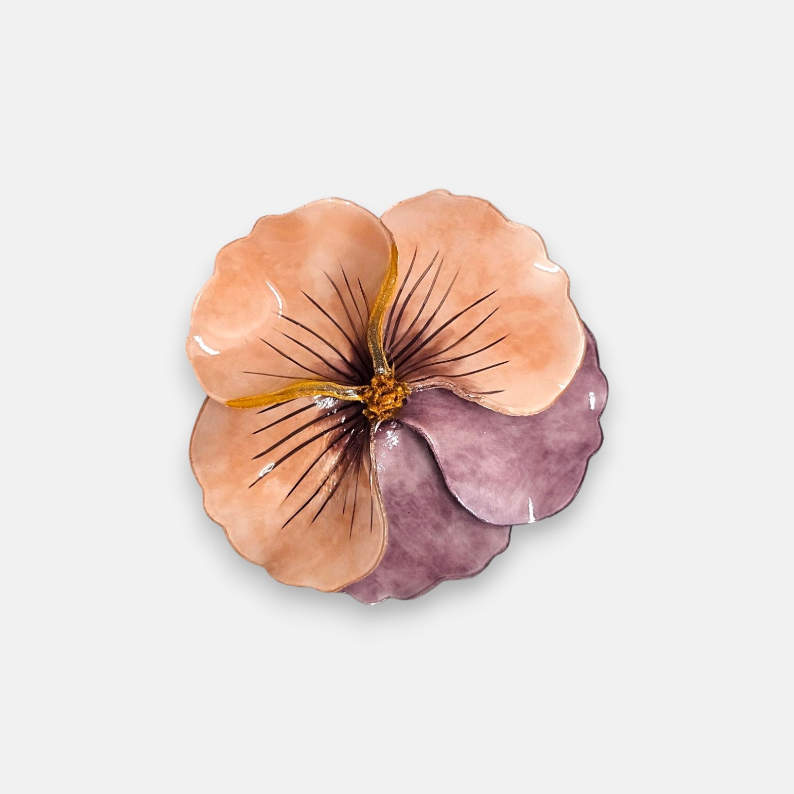 broche de gran tamaño con la silueta de una flor de pensamiento de Ciléa Paris, destacando sus pétalos superiores en tono salmón o melocotón pastel y sus pétalos inferiores en un suave color malva brillante.