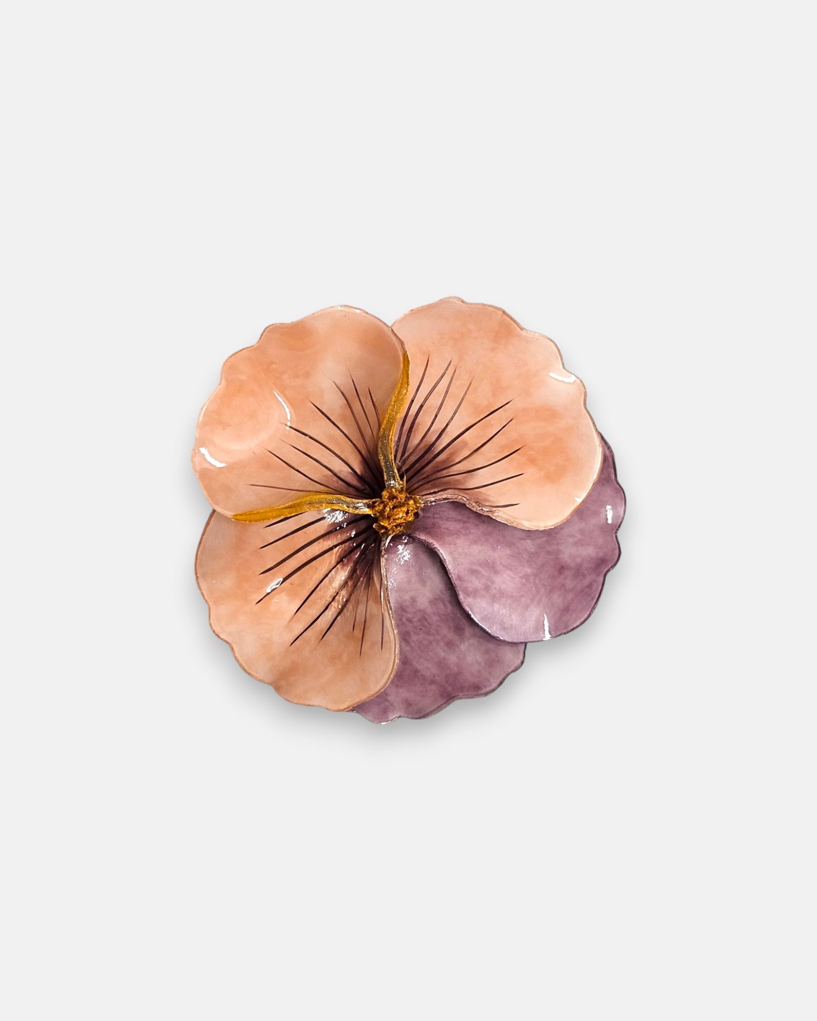 broche de gran tamaño con la silueta de una flor de pensamiento de Ciléa Paris, destacando sus pétalos superiores en tono salmón o melocotón pastel y sus pétalos inferiores en un suave color malva brillante.