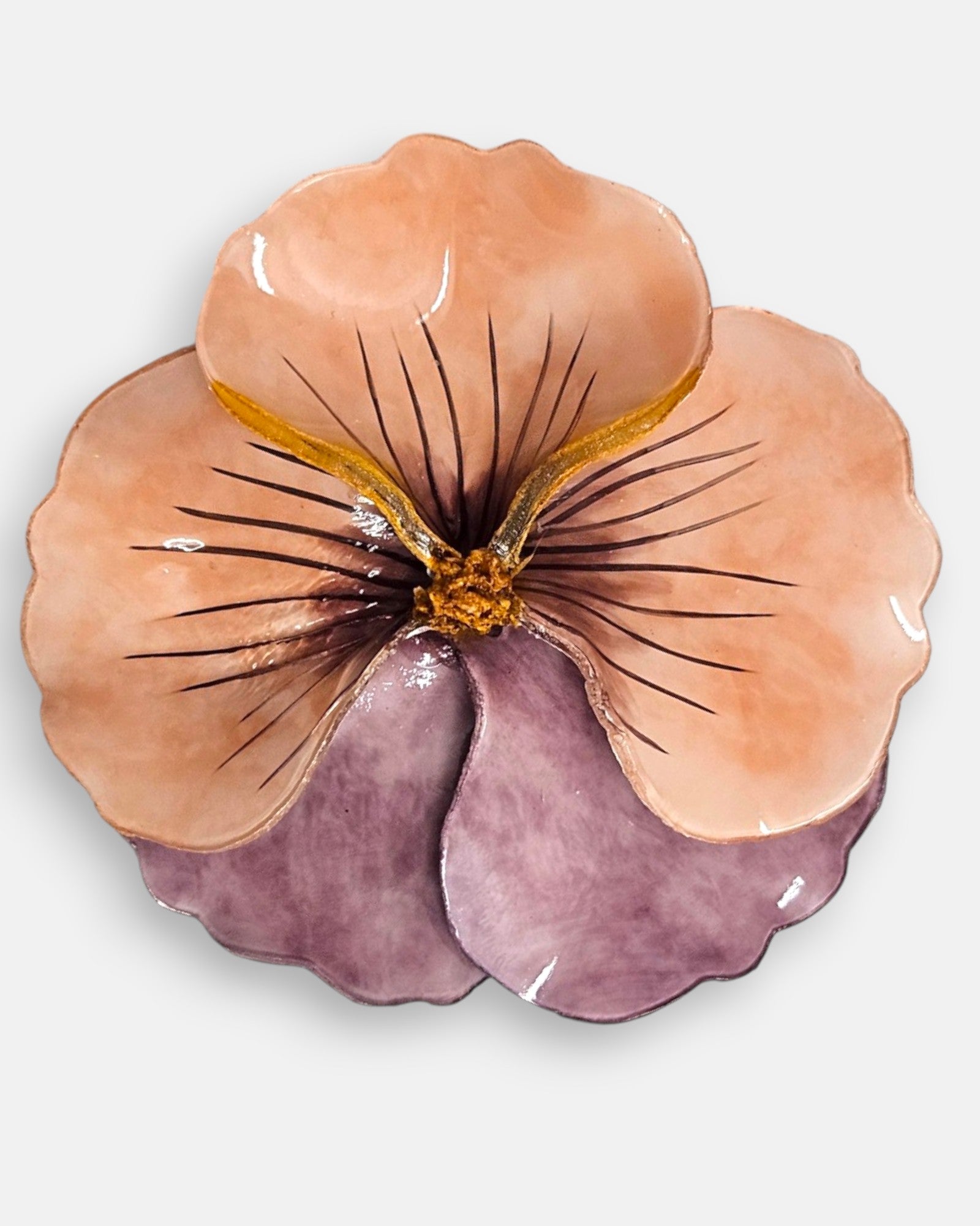 plano macro del centro de la flor del broche, enfocando las finas líneas oscuras pintadas a mano sobre el fondo salmón y los pistilos tridimensionales dorados en relieve.