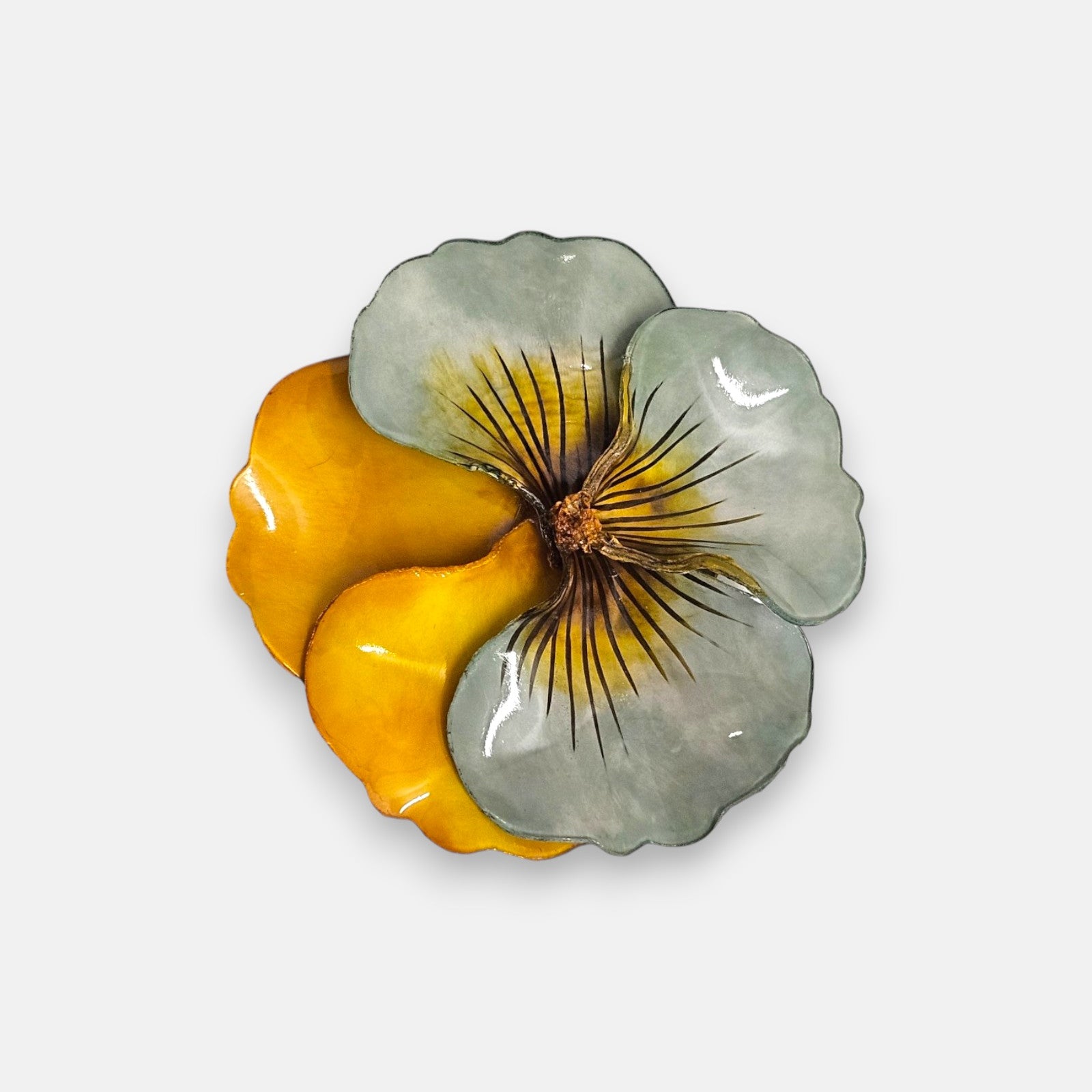 broche de gran tamaño con la silueta de una flor de pensamiento de Ciléa Paris, destacando sus pétalos superiores en un sutil tono verde menta esmaltado y sus pétalos inferiores en color ocre amarillo o ámbar brillante.