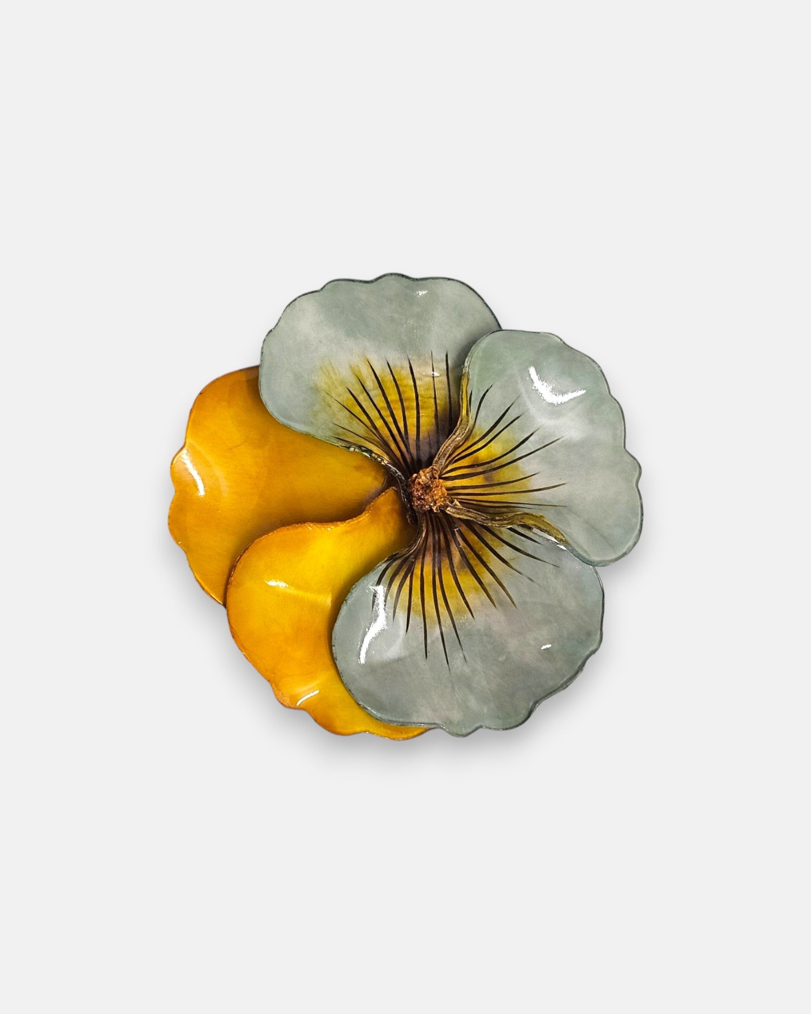 broche de gran tamaño con la silueta de una flor de pensamiento de Ciléa Paris, destacando sus pétalos superiores en un sutil tono verde menta esmaltado y sus pétalos inferiores en color ocre amarillo o ámbar brillante.
