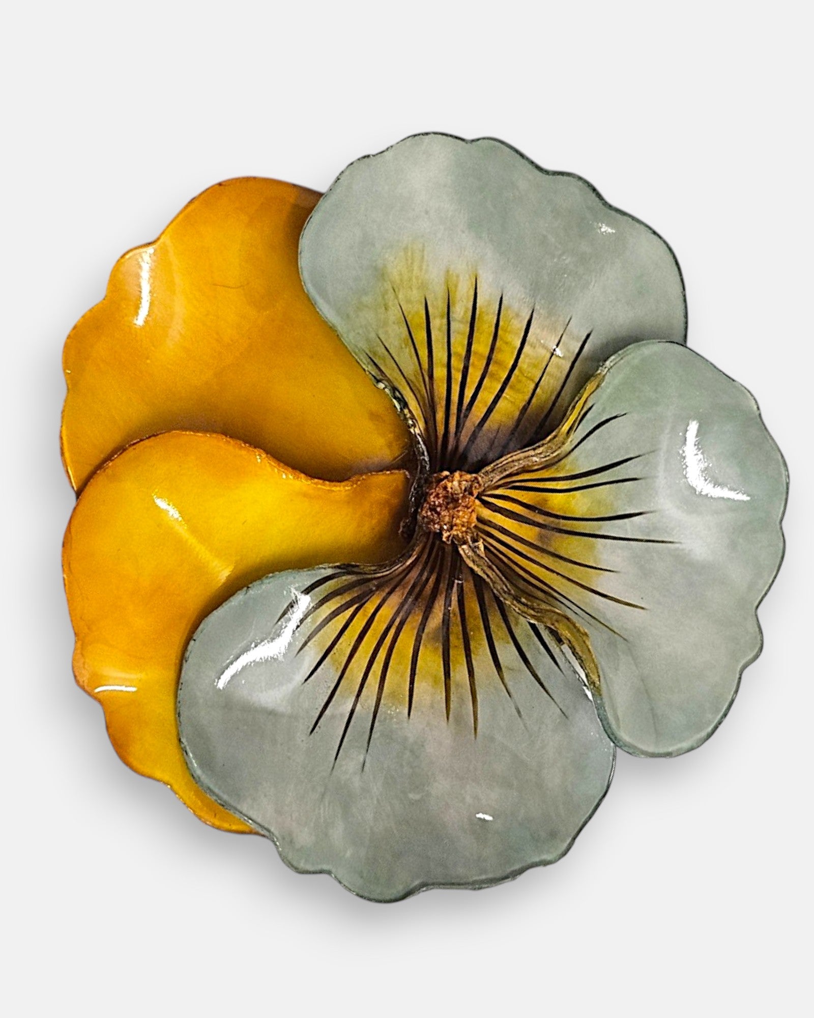plano macro del centro de la flor del broche, enfocando las finas líneas oscuras pintadas de forma artesanal y el pistilo texturizado en relieve dorado.