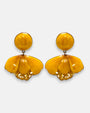 pareja de pendientes colgantes con silueta de flor de tulipán de Ciléa Paris, destacando sus pétalos de resina en color ocre dorado o miel brillante, pistilos inferiores expuestos y un gran botón superior esférico de perno coordinado.