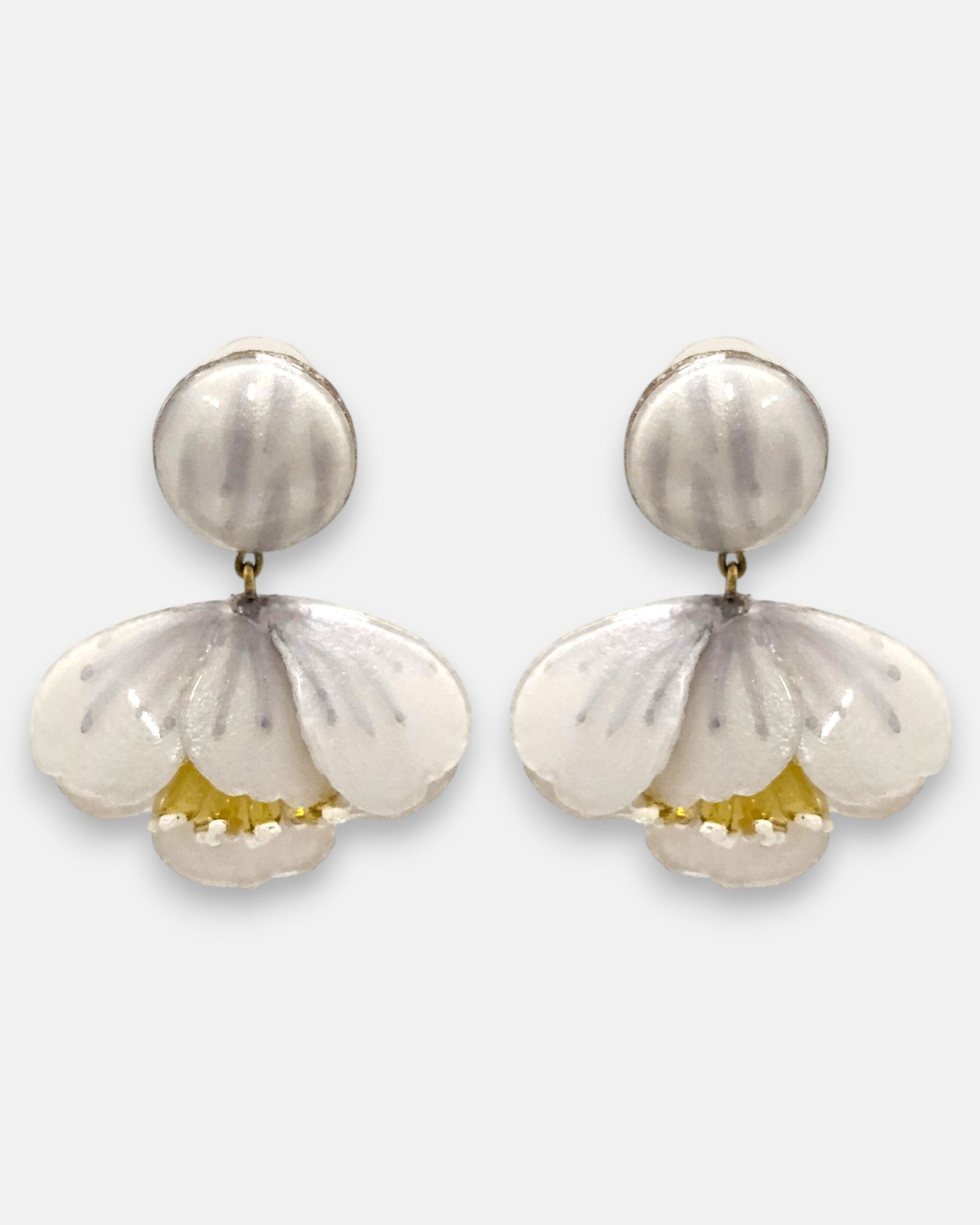 pareja de pendientes colgantes con silueta de flor de tulipán de Ciléa Paris, destacando sus pétalos de resina en color blanco nácar brillante, pistilos amarillos inferiores expuestos y un gran botón superior esférico de perno coordinado.