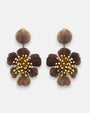 pareja de pendientes colgantes maxi con forma de flor de anémona de Ciléa Paris, destacando sus pétalos de resina en color marrón chocolate, un complejo centro de pistilos dorados con puntas blancas y un botón superior esférico a juego.