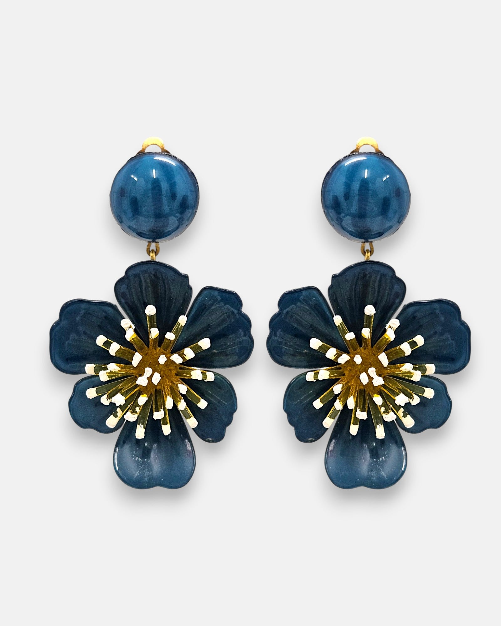 pareja de pendientes colgantes maxi con forma de flor de anémona de Ciléa Paris, destacando sus pétalos de resina en color azul petróleo brillante, un complejo centro de pistilos dorados con puntas blancas y un botón superior esférico a juego.