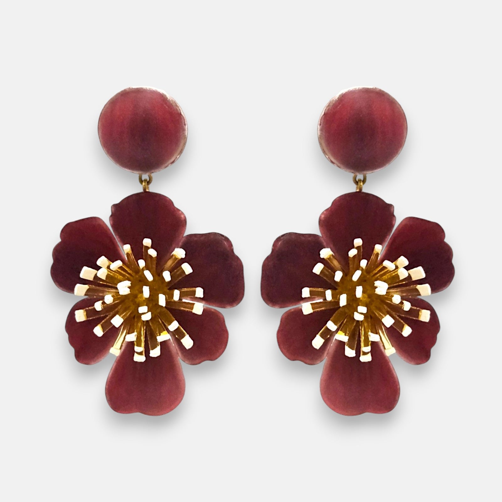 pareja de pendientes colgantes maxi con forma de flor de anémona de Ciléa Paris, destacando sus pétalos de resina en color rojo burdeos oscuro, un complejo centro de pistilos dorados con puntas blancas y un botón superior esférico de perno coordinado.
