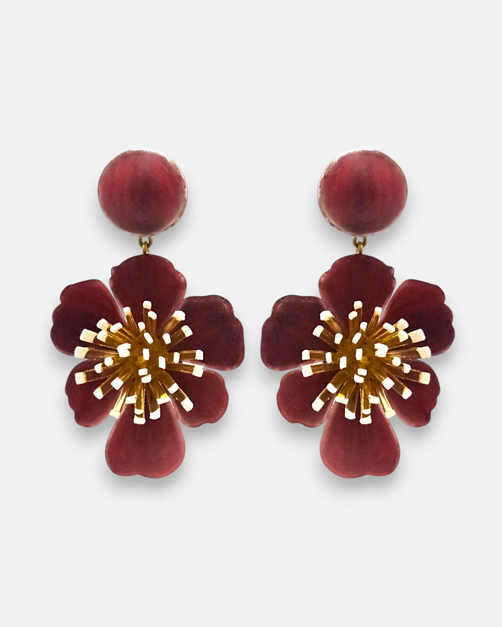 pareja de pendientes colgantes maxi con forma de flor de anémona de Ciléa Paris, destacando sus pétalos de resina en color rojo burdeos oscuro, un complejo centro de pistilos dorados con puntas blancas y un botón superior esférico de perno coordinado.