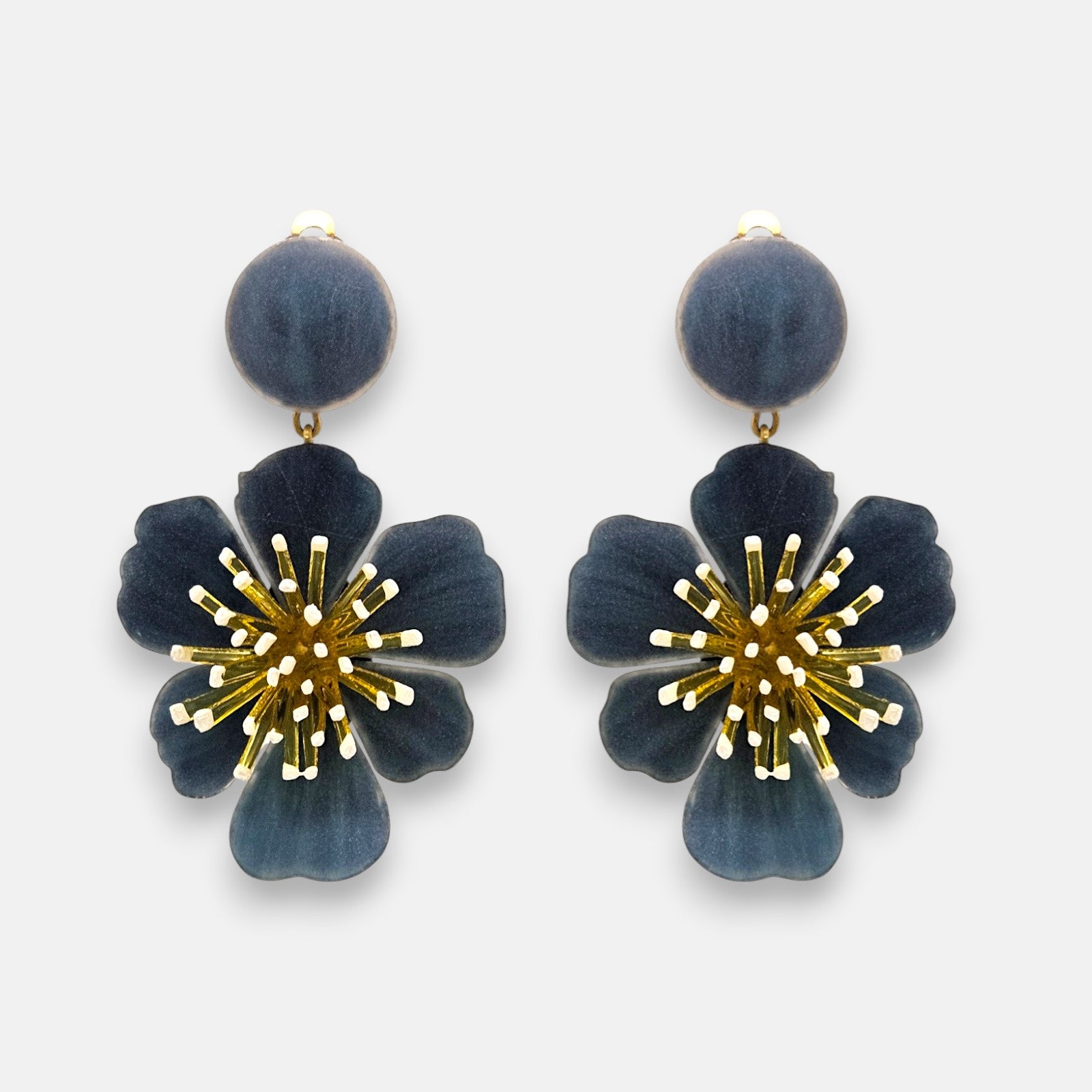 pareja de pendientes colgantes maxi con forma de flor de anémona de Ciléa Paris, destacando sus pétalos de resina en color gris antracita oscuro, un complejo centro de pistilos dorados con puntas blancas y un botón superior esférico a juego.