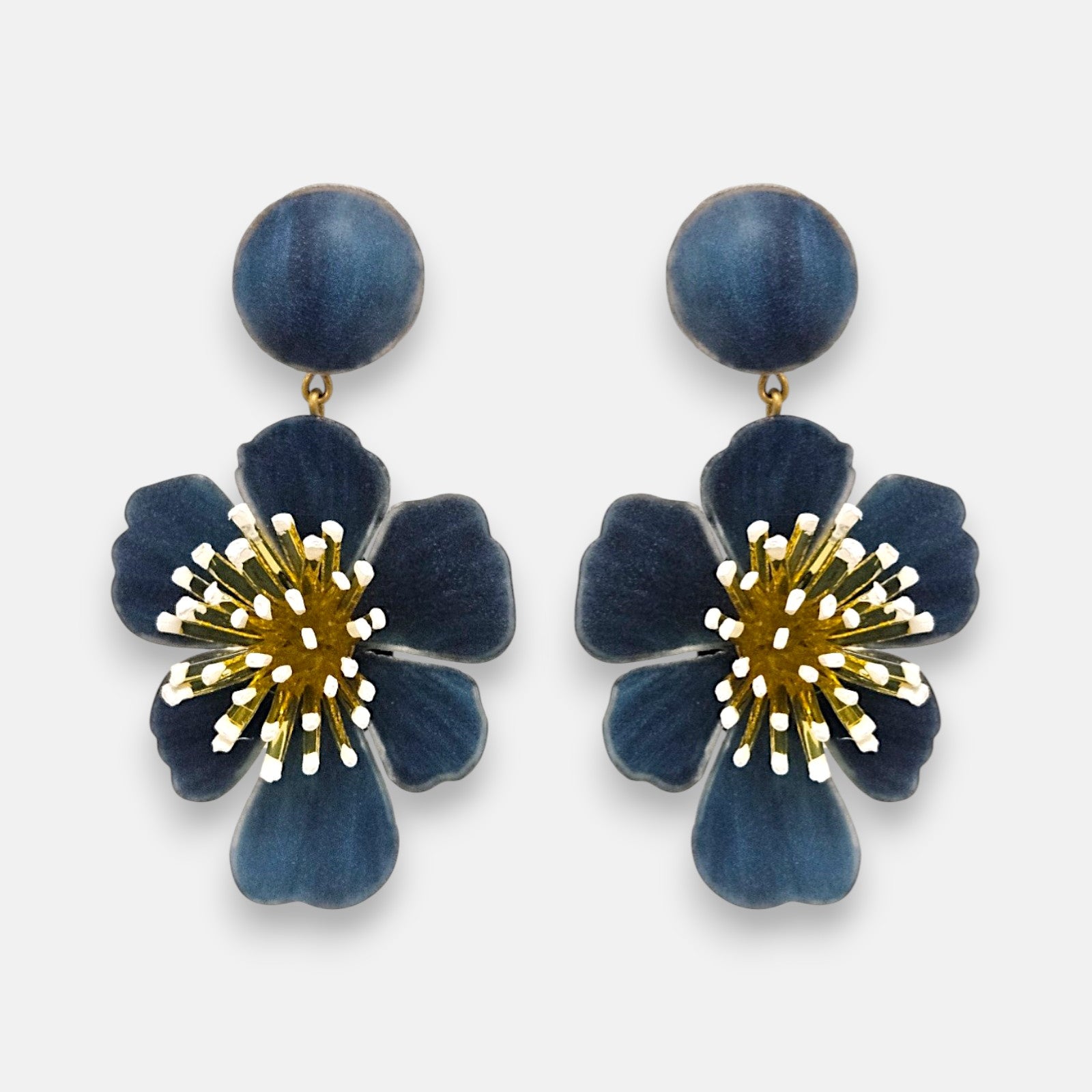 pareja de pendientes colgantes maxi con forma de flor de anémona de Ciléa Paris, destacando sus pétalos de resina en color azul denim o vaquero, un complejo centro de pistilos dorados con puntas blancas y un botón superior esférico de perno coordinado.