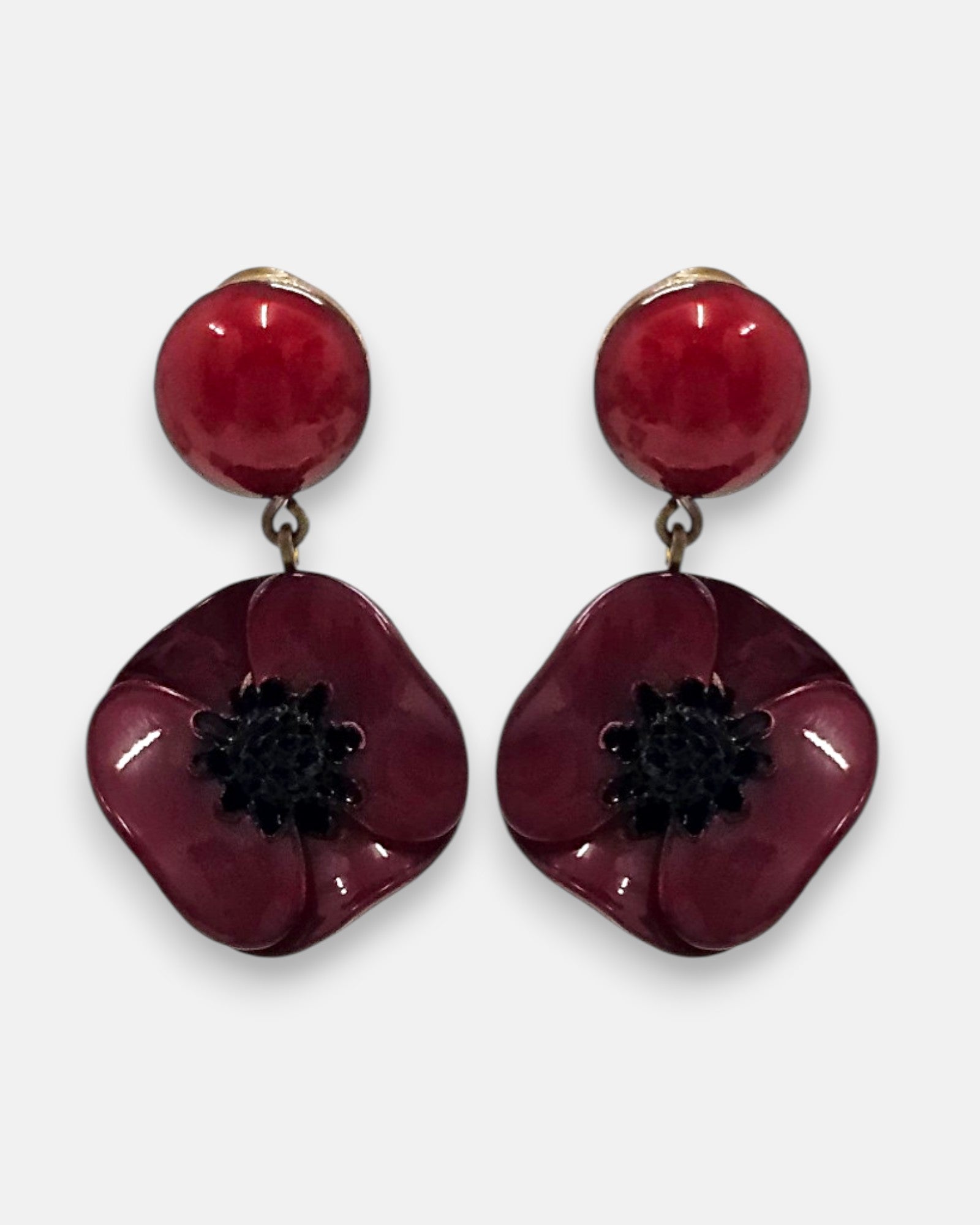 pareja de pendientes colgantes mini con silueta de flor de amapola de Ciléa Paris, destacando sus pétalos de resina en color rojo burdeos brillante, el centro negro texturizado que emula los estambres y un botón superior esférico de perno coordinado.