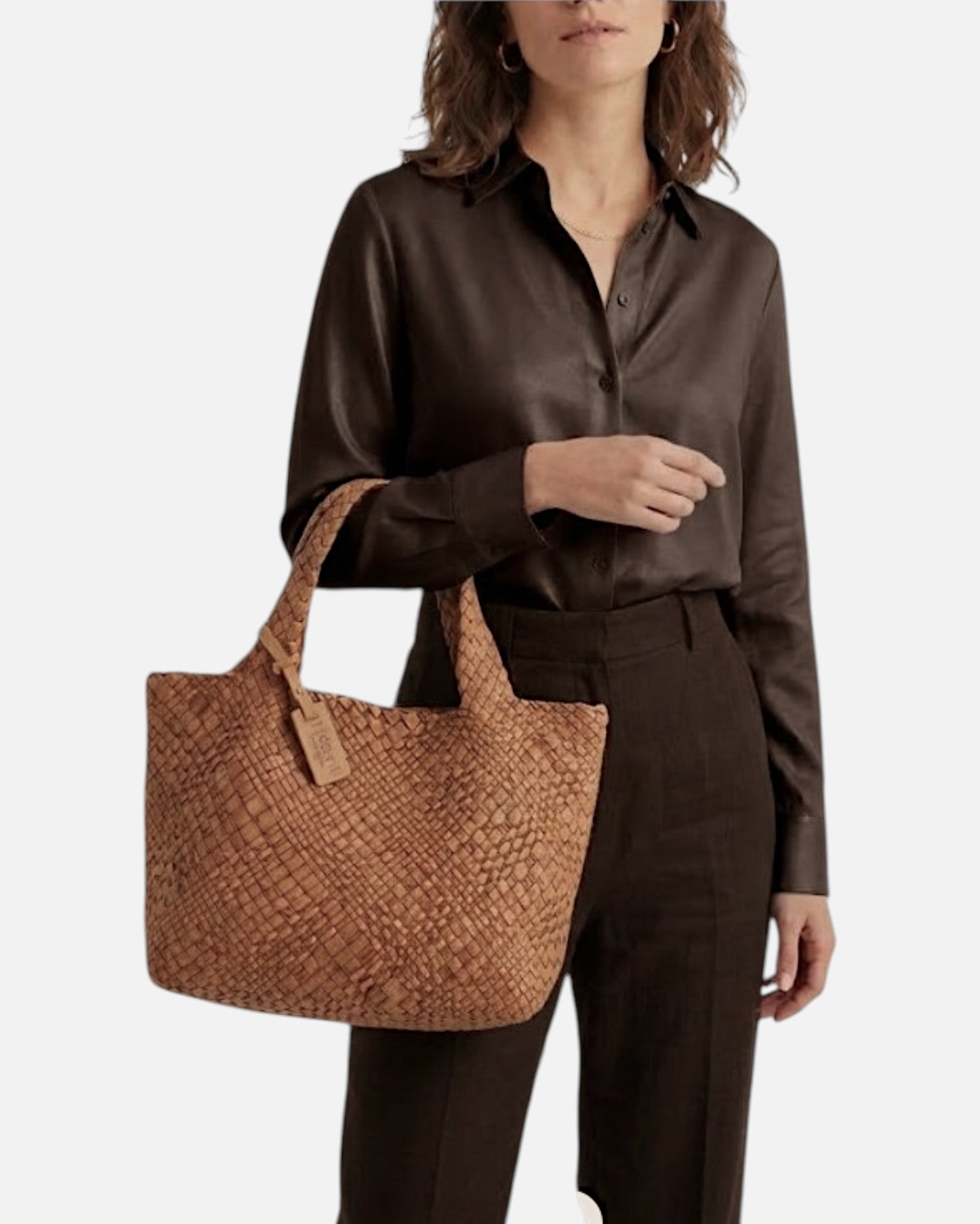 modelo luciendo en el antebrazo el Bolso Tote Intrecciato Cognac de Plinio Visonà con camisa de seda oscura.