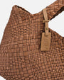 primer plano macro del entramado de piel del Bolso Tote Intrecciato Cognac de Plinio Visonà y la etiqueta con la inscripción "Visonà Made in Italy".