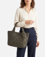 modelo luciendo en la mano el Bolso Tote Intrecciato Salvia de Plinio Visonà vistiendo blusa clara y pantalón marino.