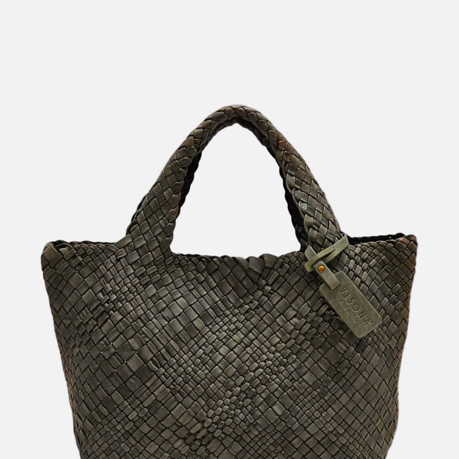 Bolso Tote Intrecciato Salvia de Plinio Visonà en piel trenzada verde oliva con etiqueta colgante de la firma.