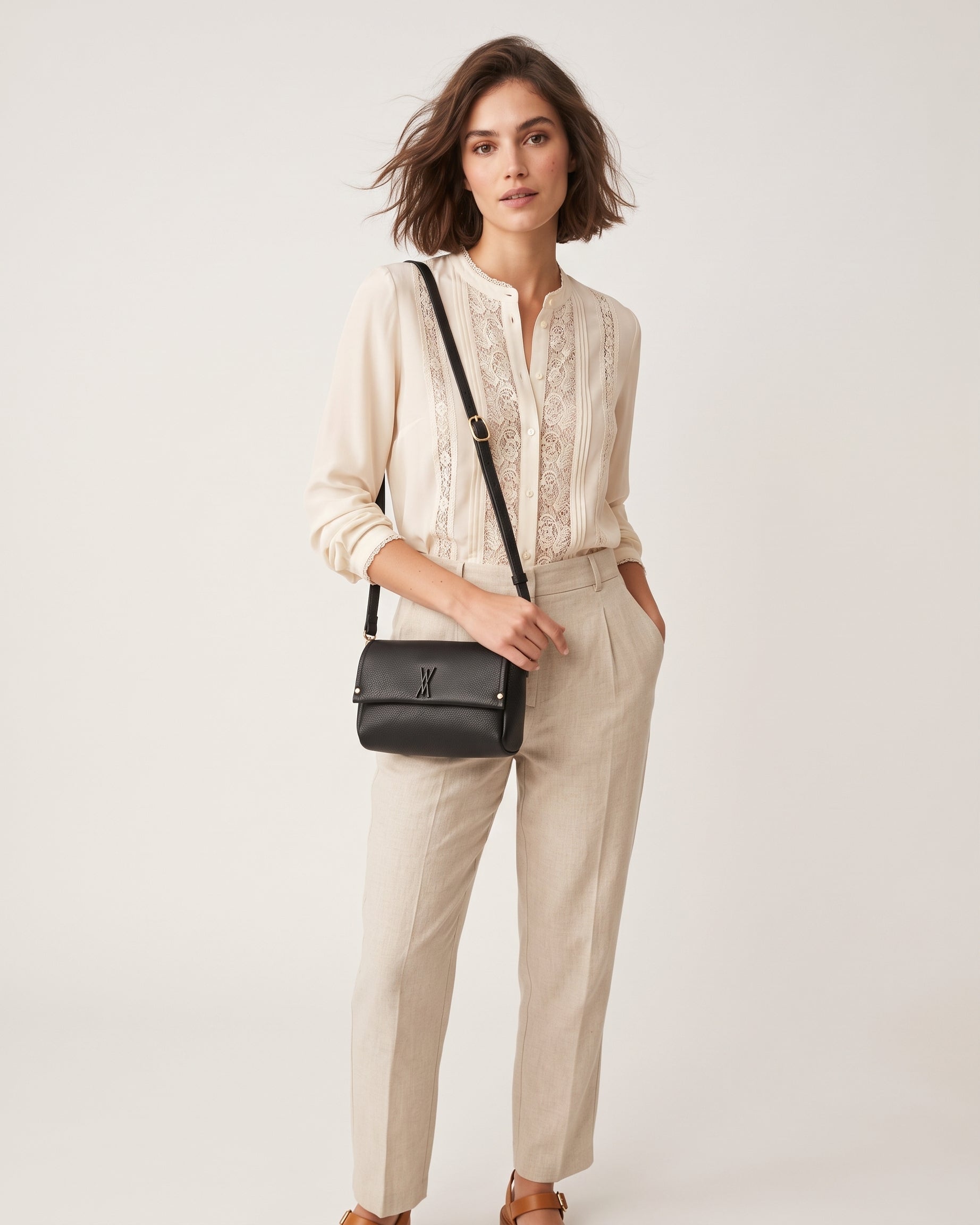 modelo luciendo cruzado el Bolso Bandolera Noir de Plinio Visonà sobre un jersey beige y pantalón verde.