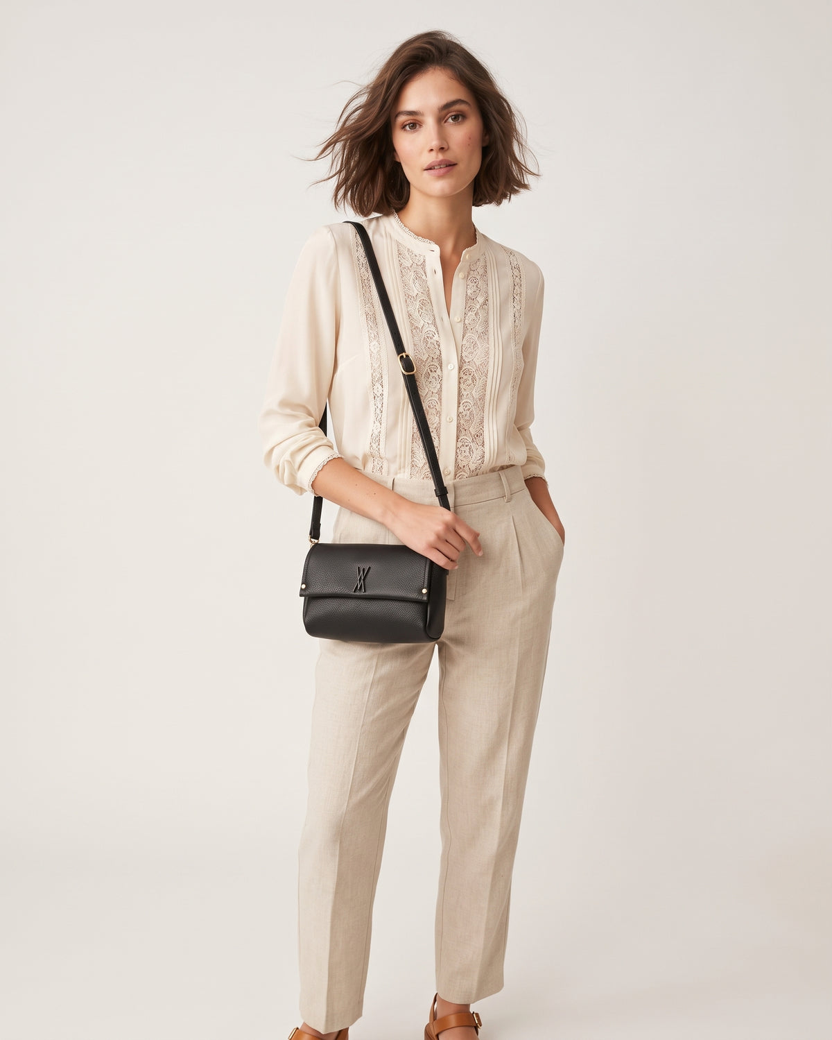 modelo luciendo cruzado el Bolso Bandolera Noir de Plinio Visonà sobre un jersey beige y pantalón verde.