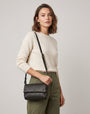 modelo luciendo cruzado el Bolso Bandolera Verde Musgo de Plinio Visonà sobre un jersey beige y pantalón verde.