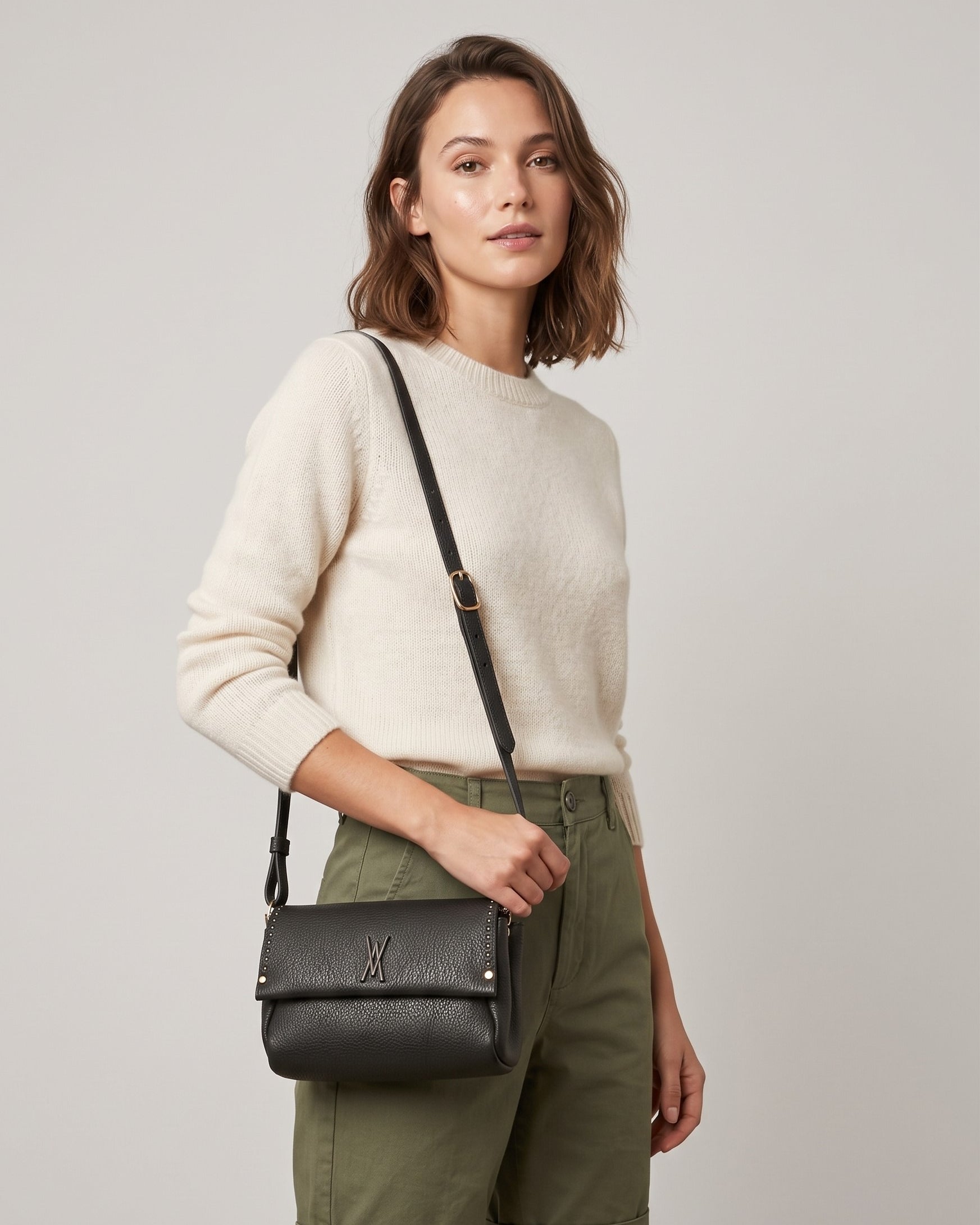 modelo luciendo cruzado el Bolso Bandolera Verde Musgo de Plinio Visonà sobre un jersey beige y pantalón verde.