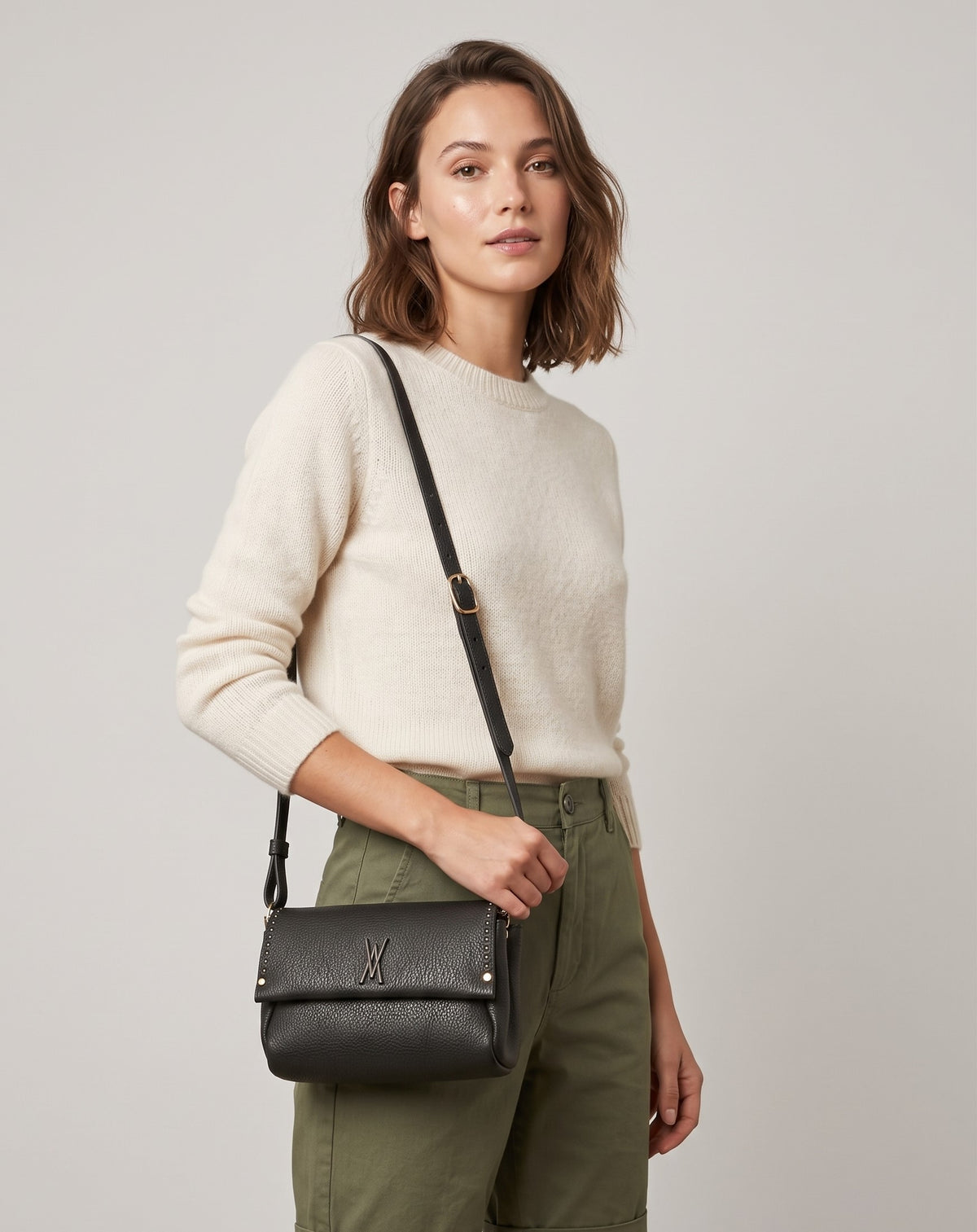 modelo luciendo cruzado el Bolso Bandolera Verde Musgo de Plinio Visonà sobre un jersey beige y pantalón verde.