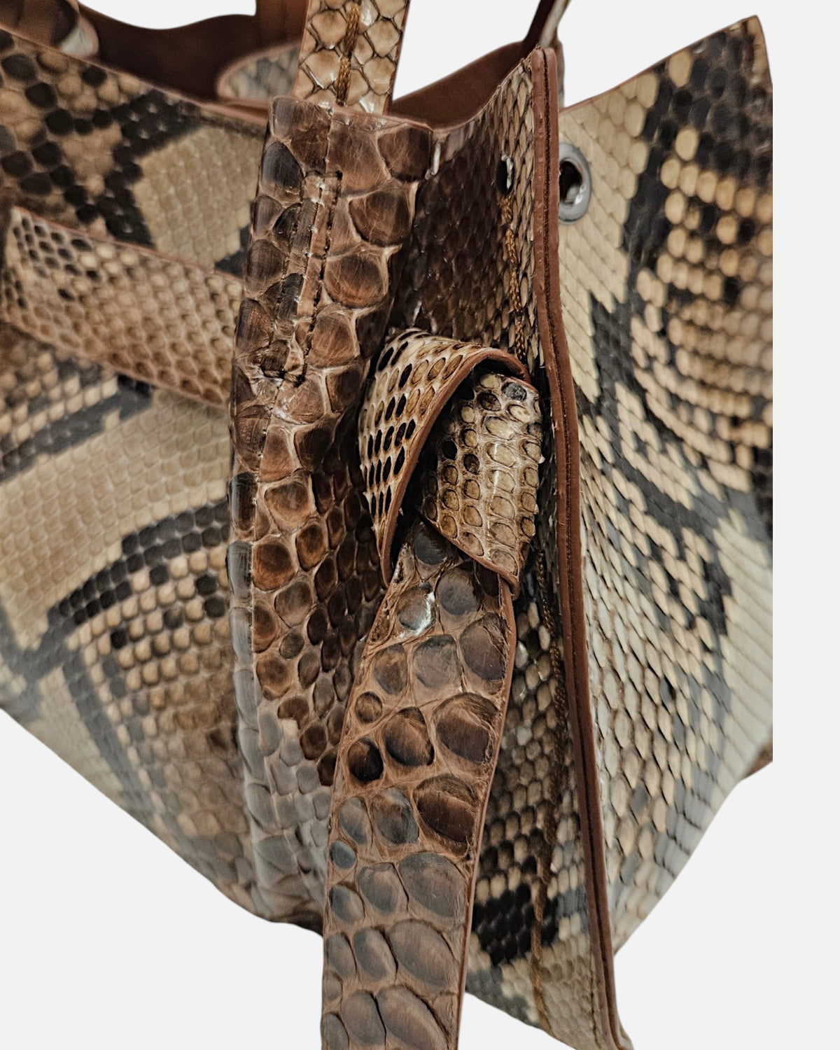 primer plano del nudo lateral en piel estampada de serpiente del Bolso Pitón Pitagora de Plinio Visonà.