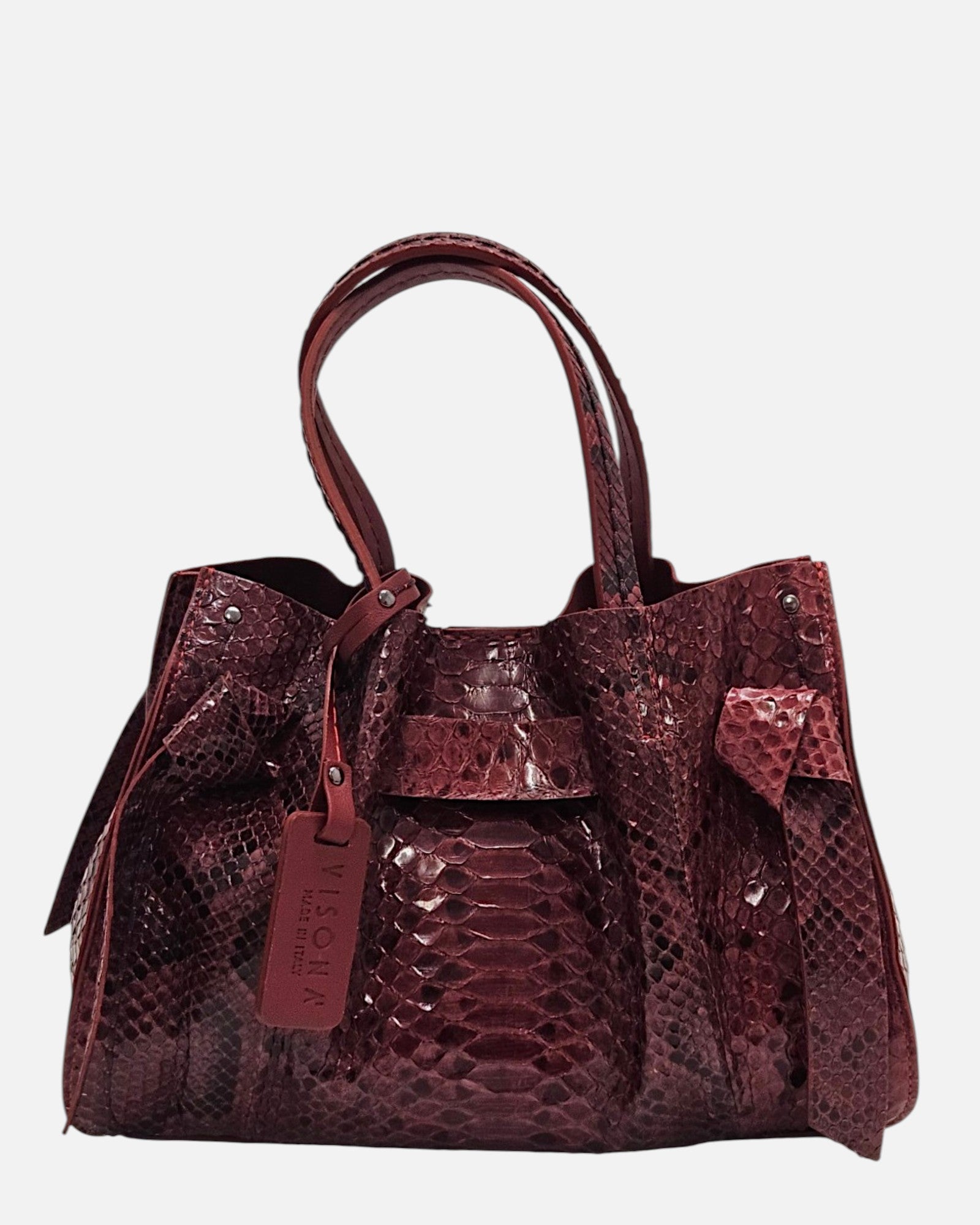 Bolso Pitón Pitagora Bordeus de Plinio Visonà en piel burdeos de grabado pitón con nudos laterales y etiqueta colgante.