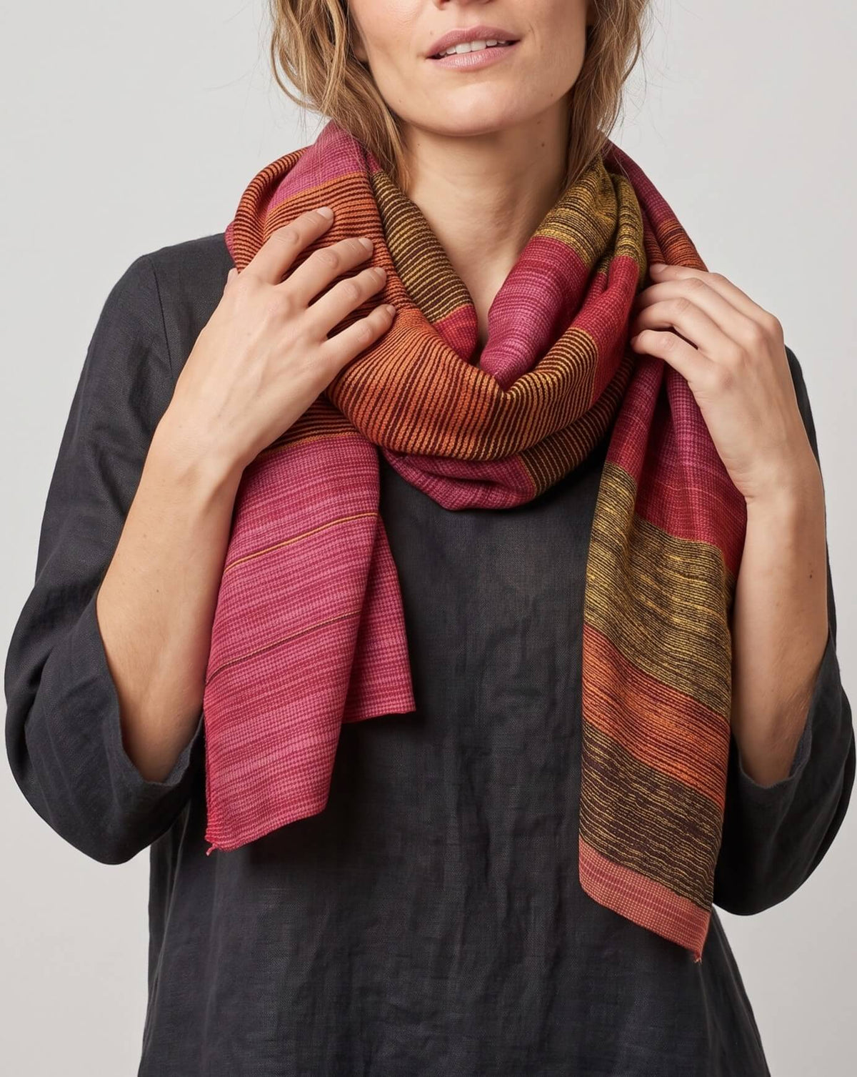 modelo luciendo el Foulard Riga Carmine anudado al cuello en bucle sobre una prenda oscura.   