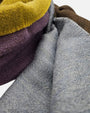 se exhibe extendido en vertical el Foulard Blok Pastel, apreciando la distribución de los bloques geométricos de color y las cenefas a rayas de los bordes.   