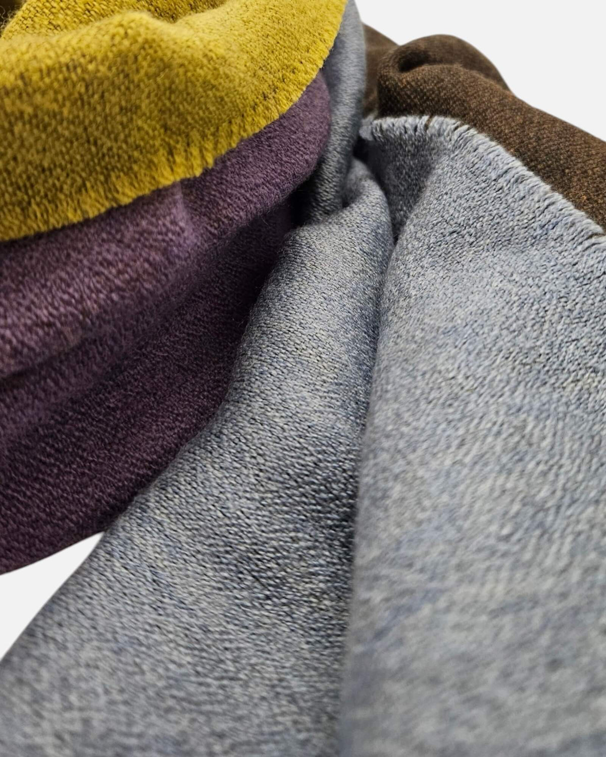 se exhibe extendido en vertical el Foulard Blok Pastel, apreciando la distribución de los bloques geométricos de color y las cenefas a rayas de los bordes.   