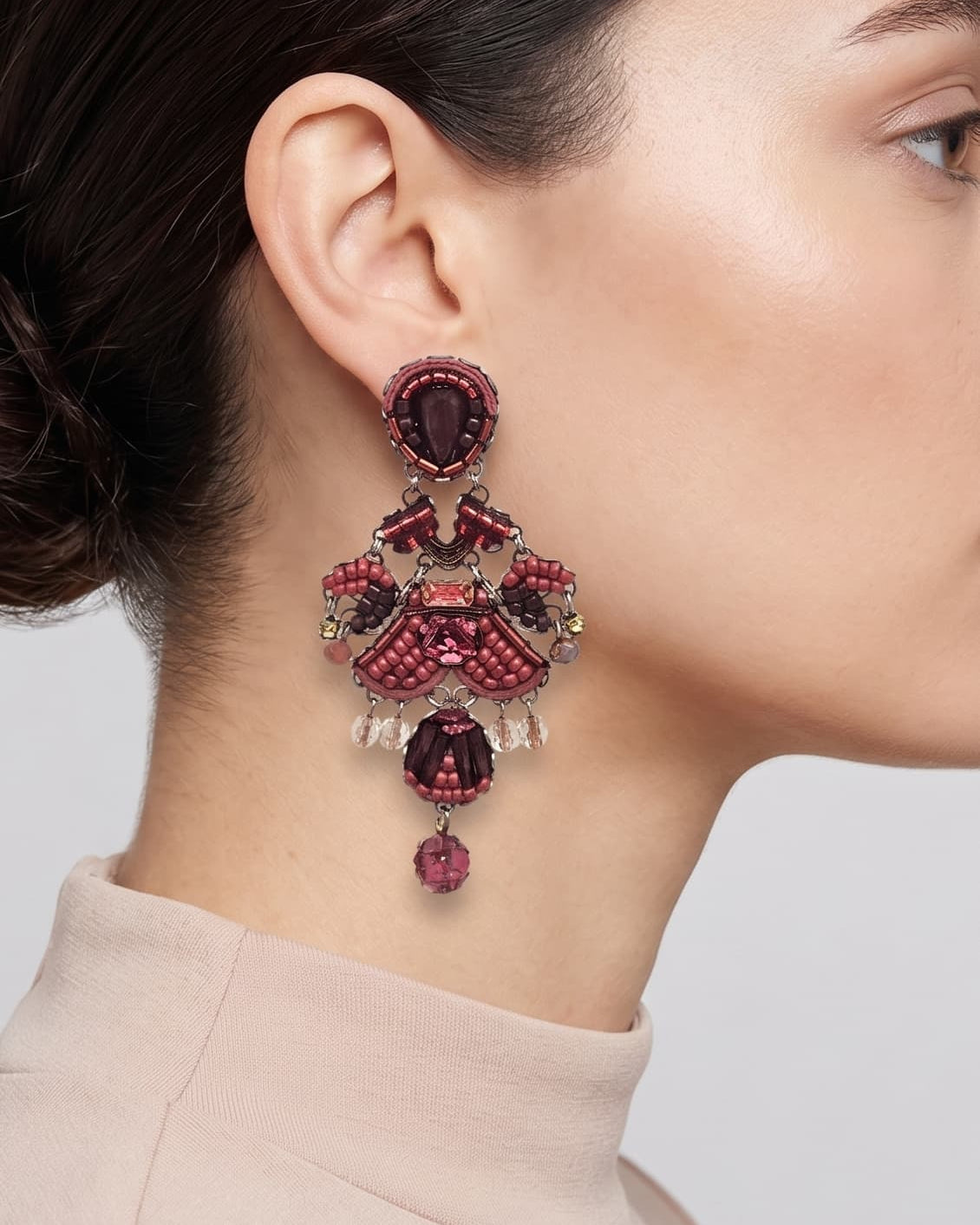 modelo de perfil luciendo uno de los pendientes colgantes de Ayala Bar, apreciando su longitud, su escala bohemia y cómo adorna el lateral del cuello.