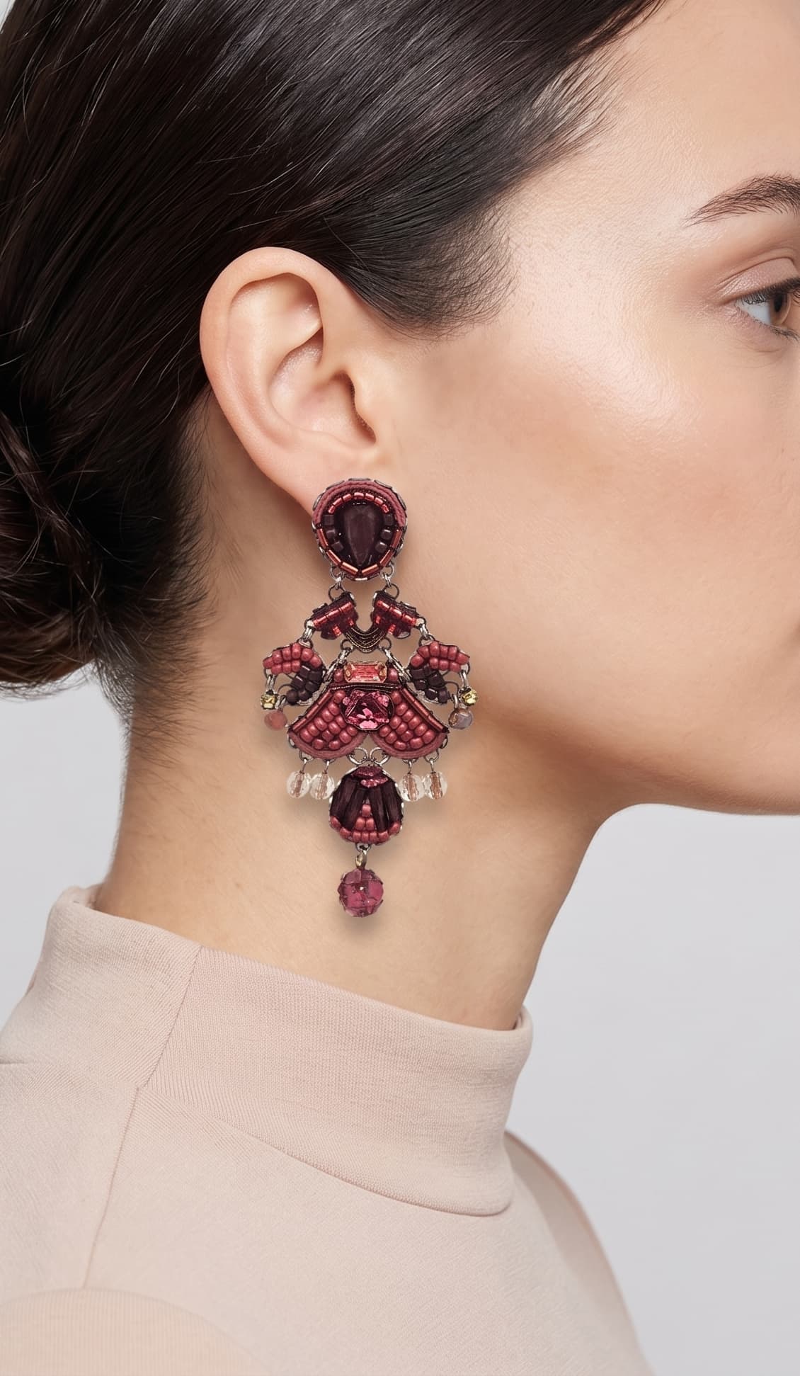 modelo de perfil luciendo uno de los pendientes colgantes de Ayala Bar, apreciando su longitud, su escala bohemia y cómo adorna el lateral del cuello.