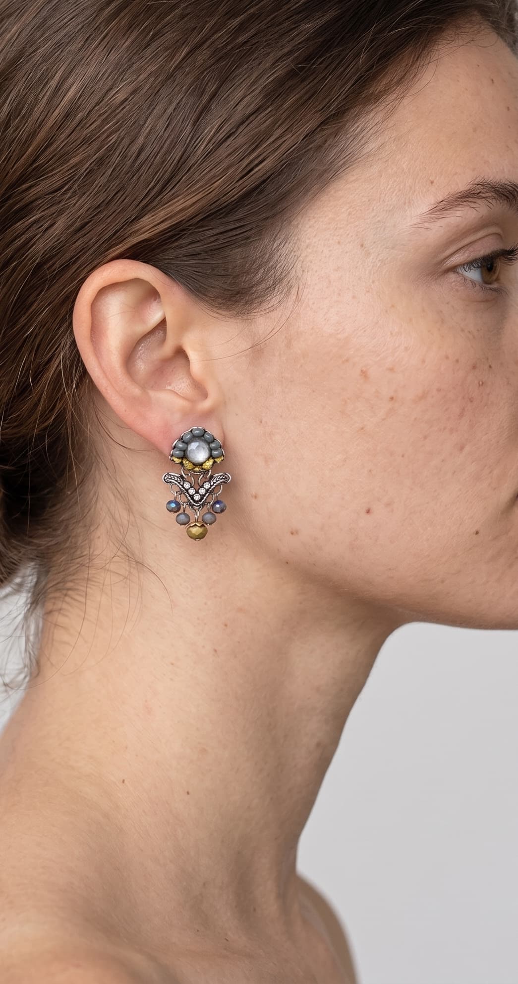 modelo luciendo uno de los pendientes articulados de Ayala Bar, mostrando su escala y cómo se asienta elegantemente sobre el lóbulo de la oreja.