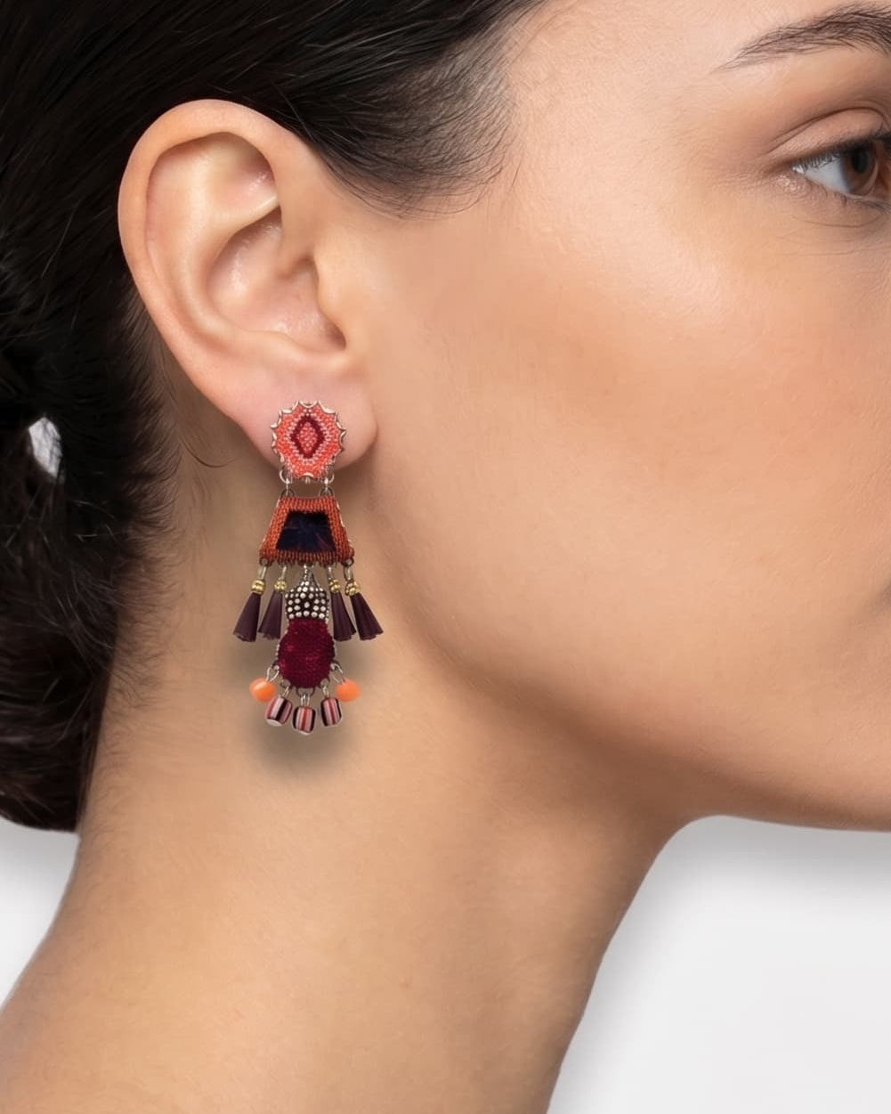 modelo de perfil luciendo uno de los pendientes de estilo étnico de Ayala Bar, apreciando cómo asienta la pieza y el balance de sus colgantes bajo la oreja.