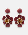 Pareja de pendientes grandes en forma de flor de Ciléa Paris, mostrando sus pétalos ondulados en color rojo guinda esmaltado y botón central a juego.