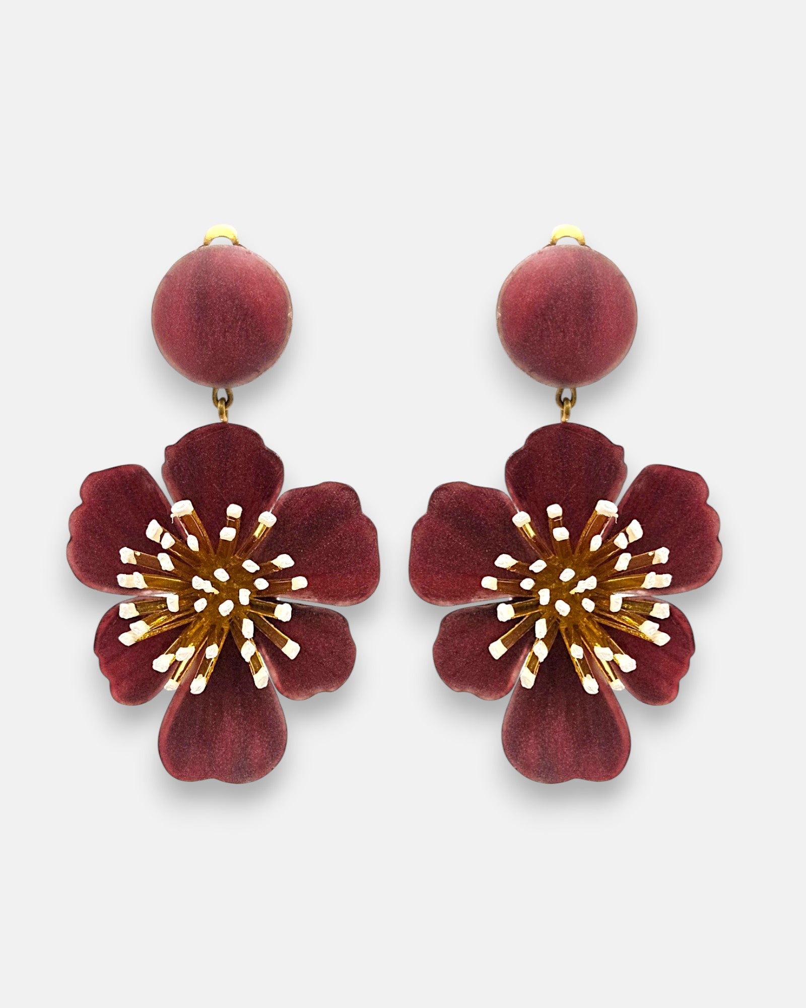 Pareja de pendientes grandes en forma de flor de Ciléa Paris, mostrando sus pétalos ondulados en color rojo guinda esmaltado y botón central a juego.