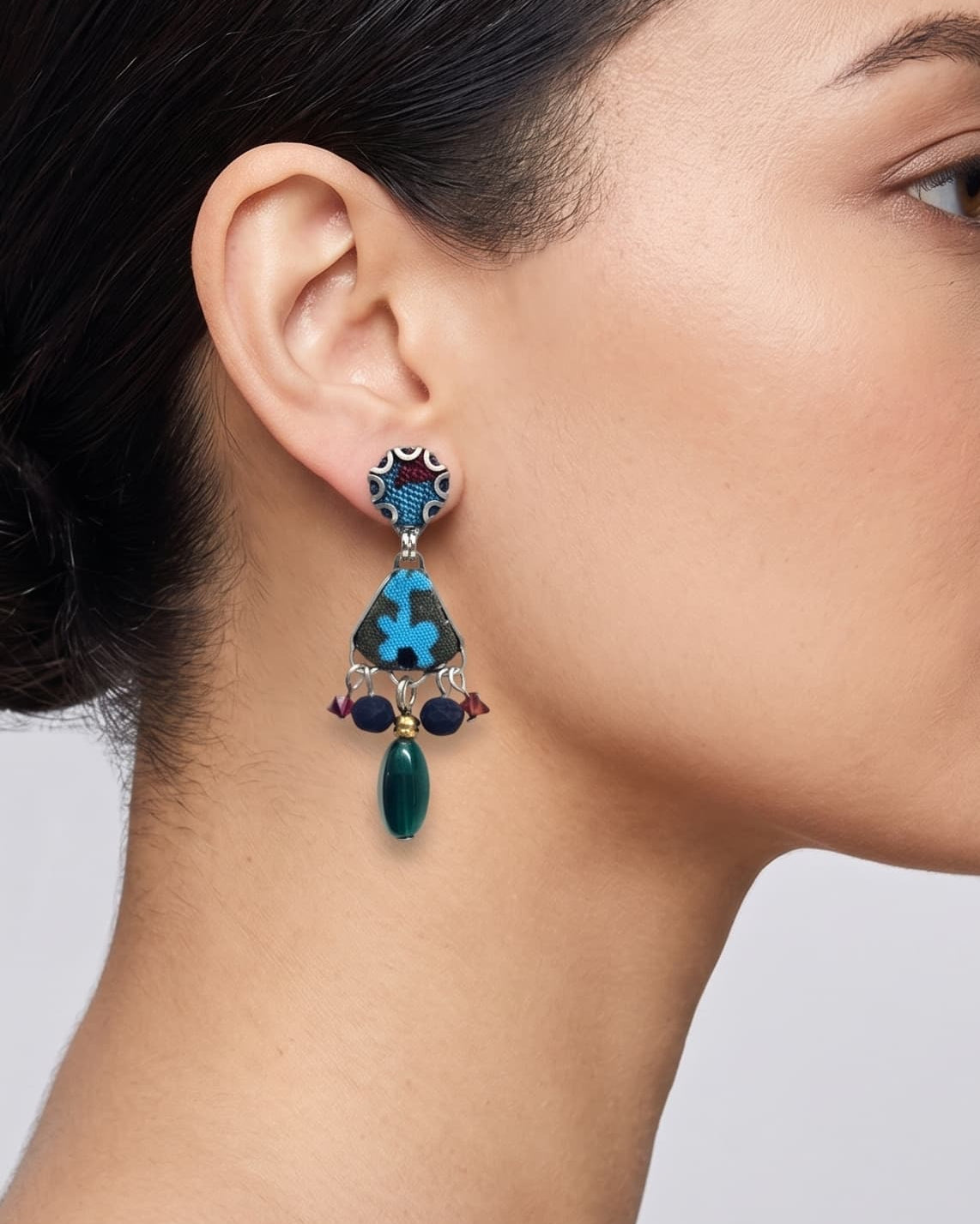 modelo de perfil luciendo uno de los pendientes de Ayala Bar, apreciando cómo se asienta sobre el lóbulo de la oreja y estiliza la línea del cuello.