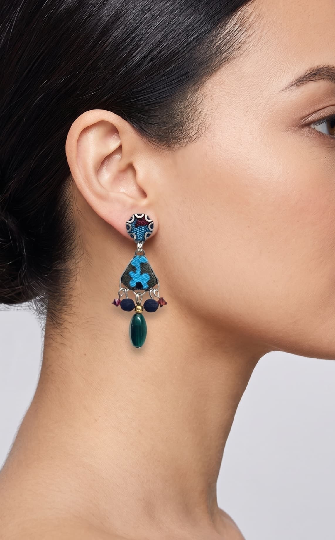 modelo de perfil luciendo uno de los pendientes de Ayala Bar, apreciando cómo se asienta sobre el lóbulo de la oreja y estiliza la línea del cuello.