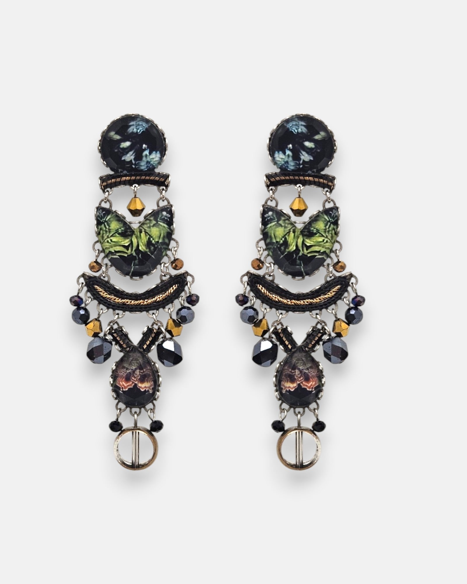 par de pendientes de frente sobre fondo claro, destacando su silueta alargada de estilo mosaico con cabujones textiles verdes y colgantes facetados.