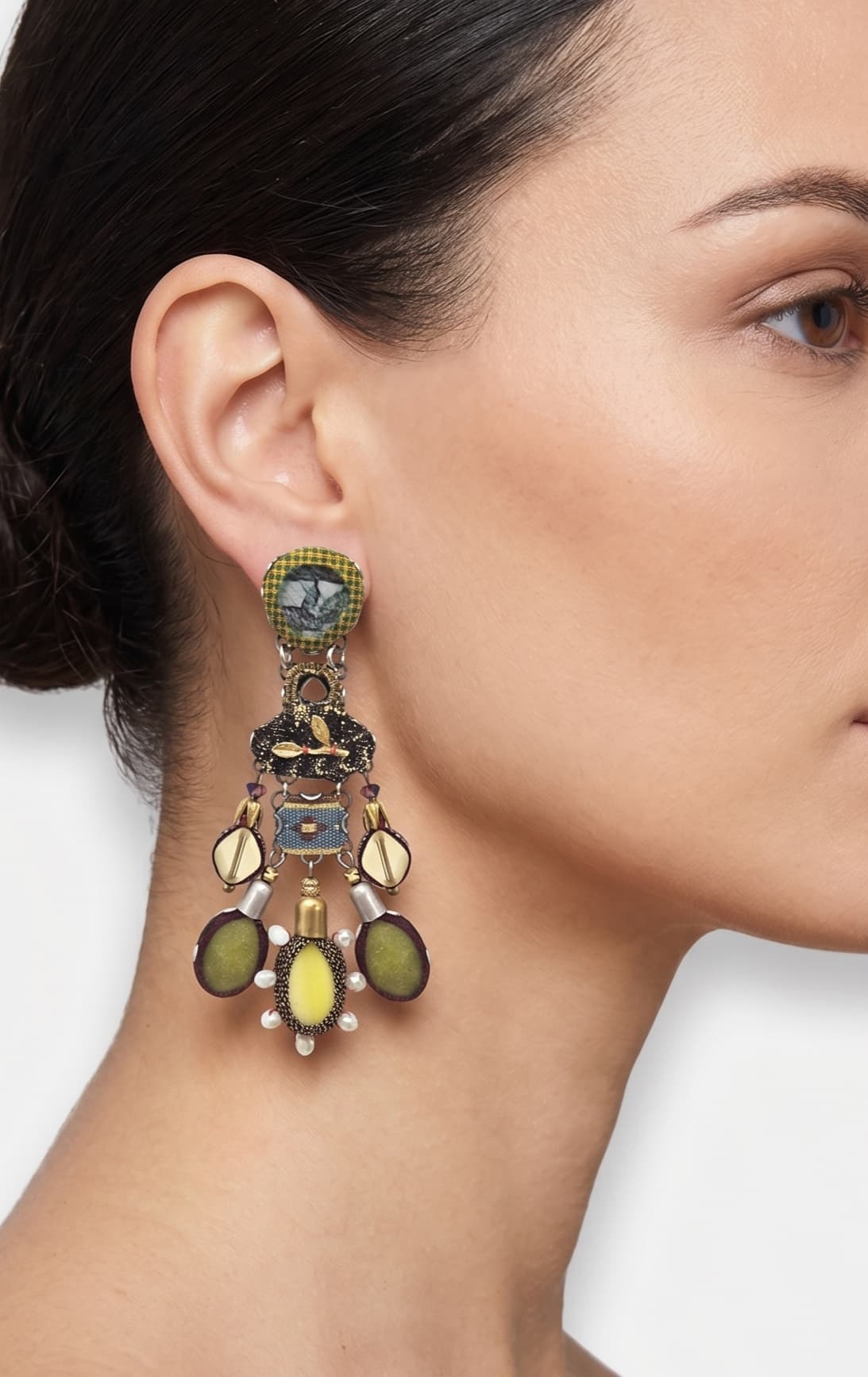modelo de perfil luciendo uno de los pendientes colgantes de Ayala Bar, apreciando su longitud, escala bohemia y cómo adorna el lateral del rostro.
